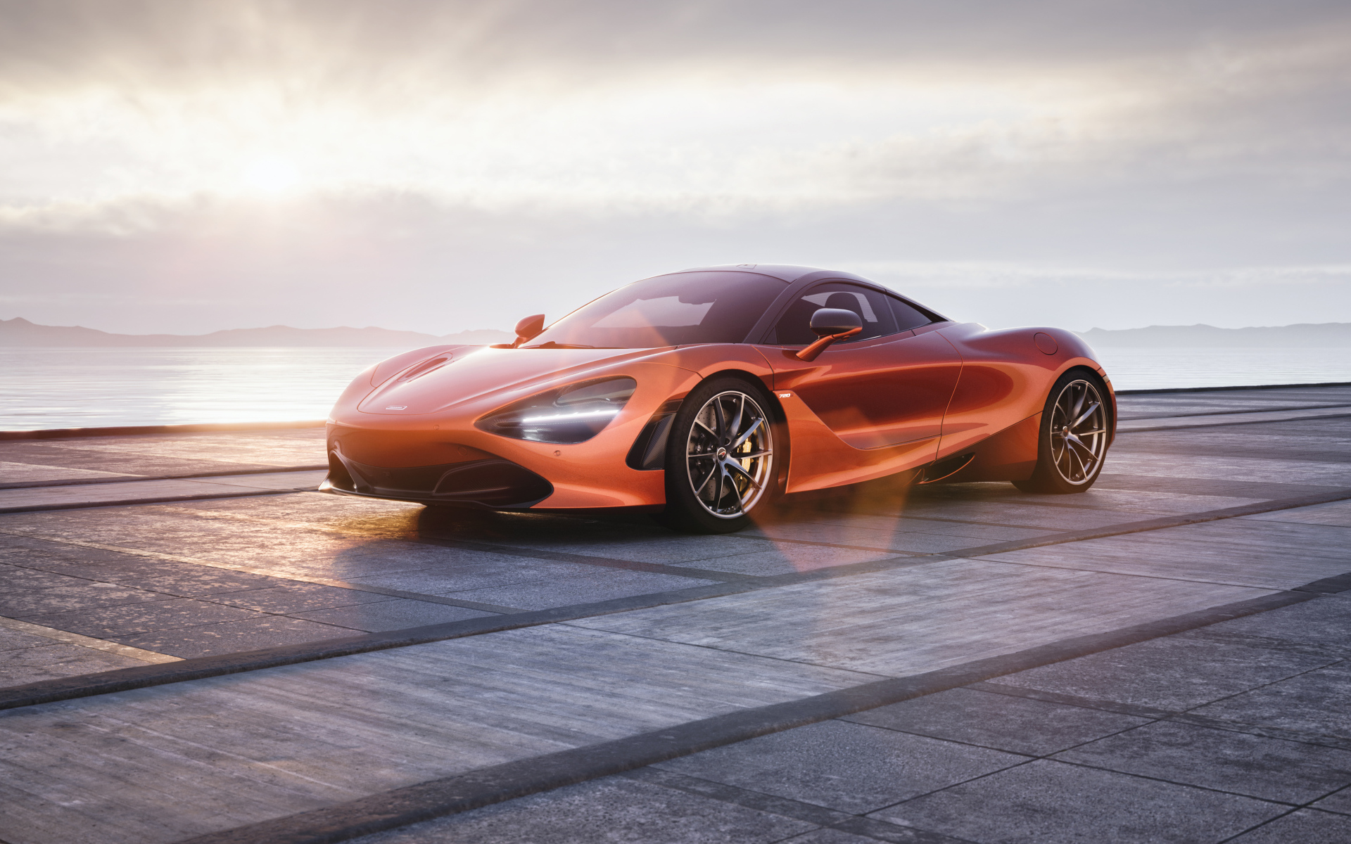 Оранжевый автомобиль McLaren 720S у озера
