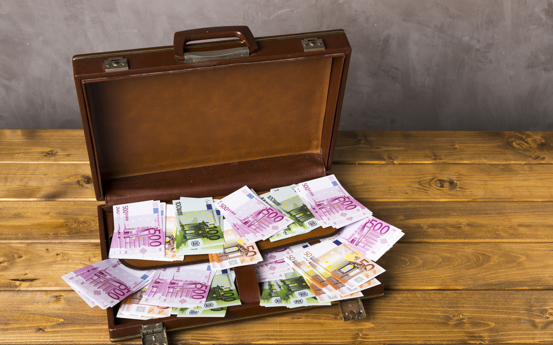 Большой кожаный чемодан с купюрами евро