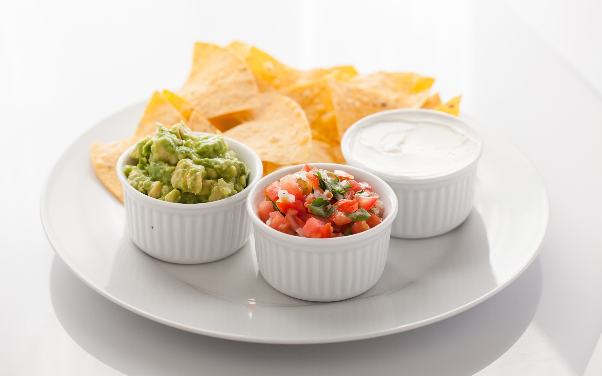 Чипсы с соусом на большой белой тарелке