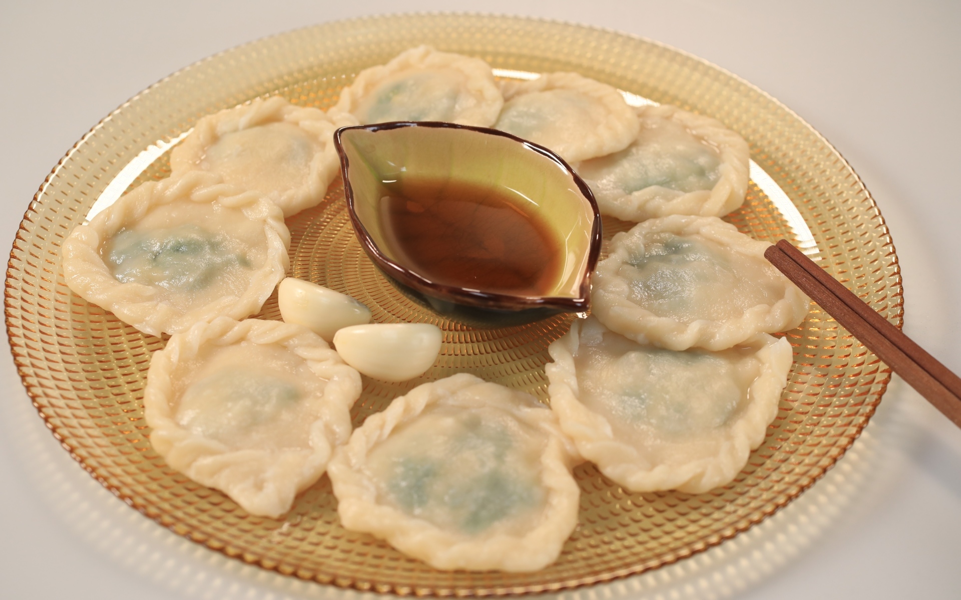 Блюдо дамплинг с соусом и чесноком на тарелке