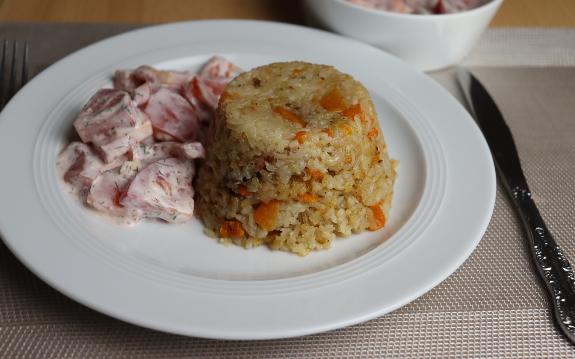 Рис с салатом на большой белой тарелке