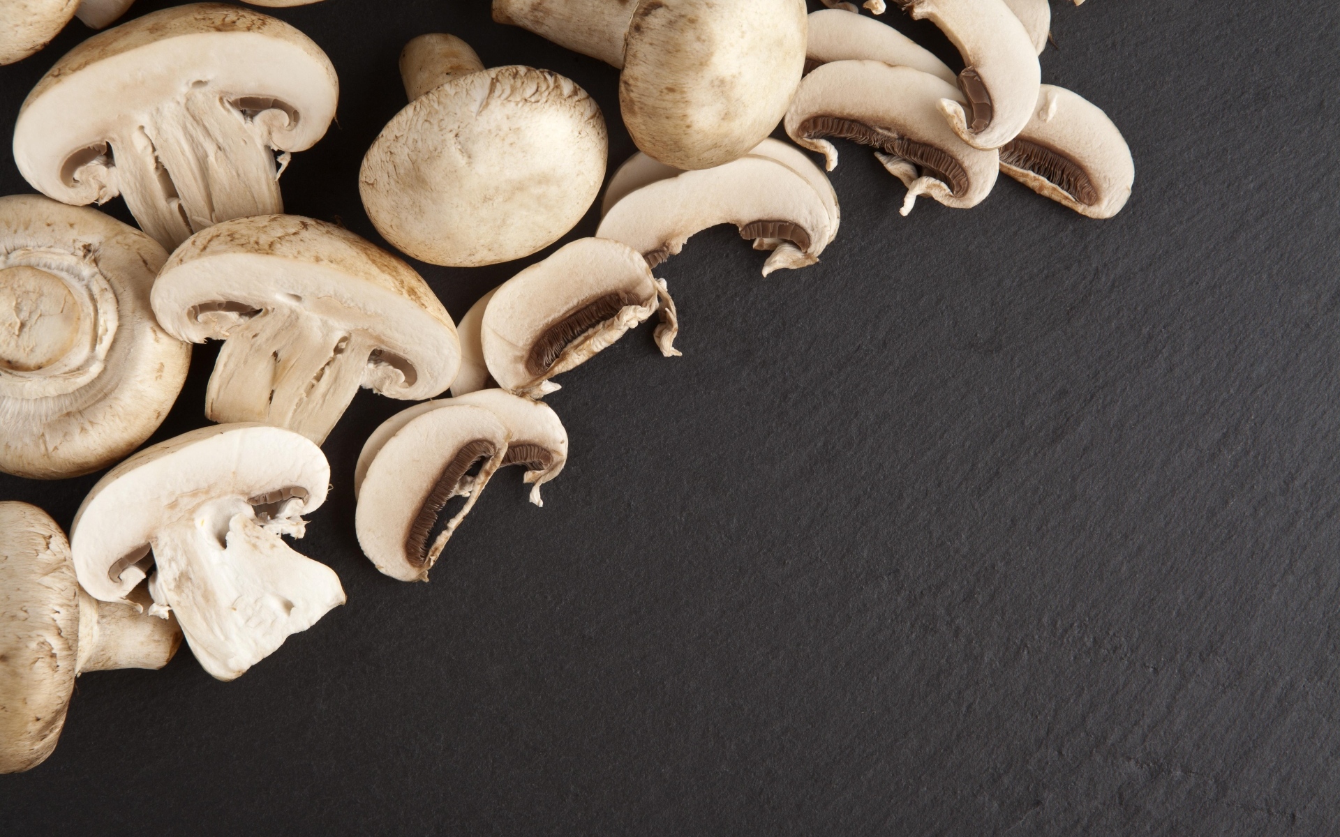 Нарезанные шампиньоны на сером столе