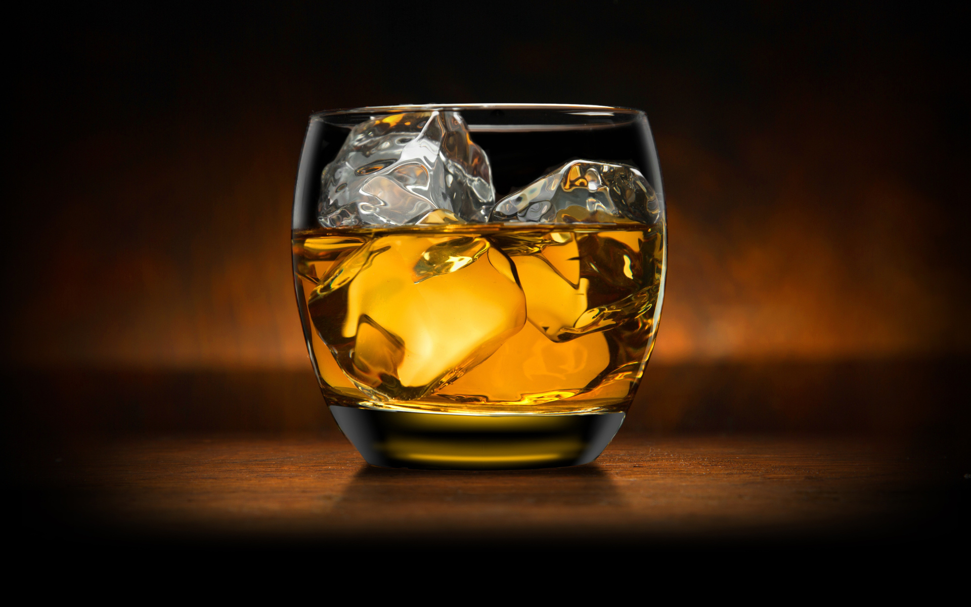 Стакан виски со льдом на столе