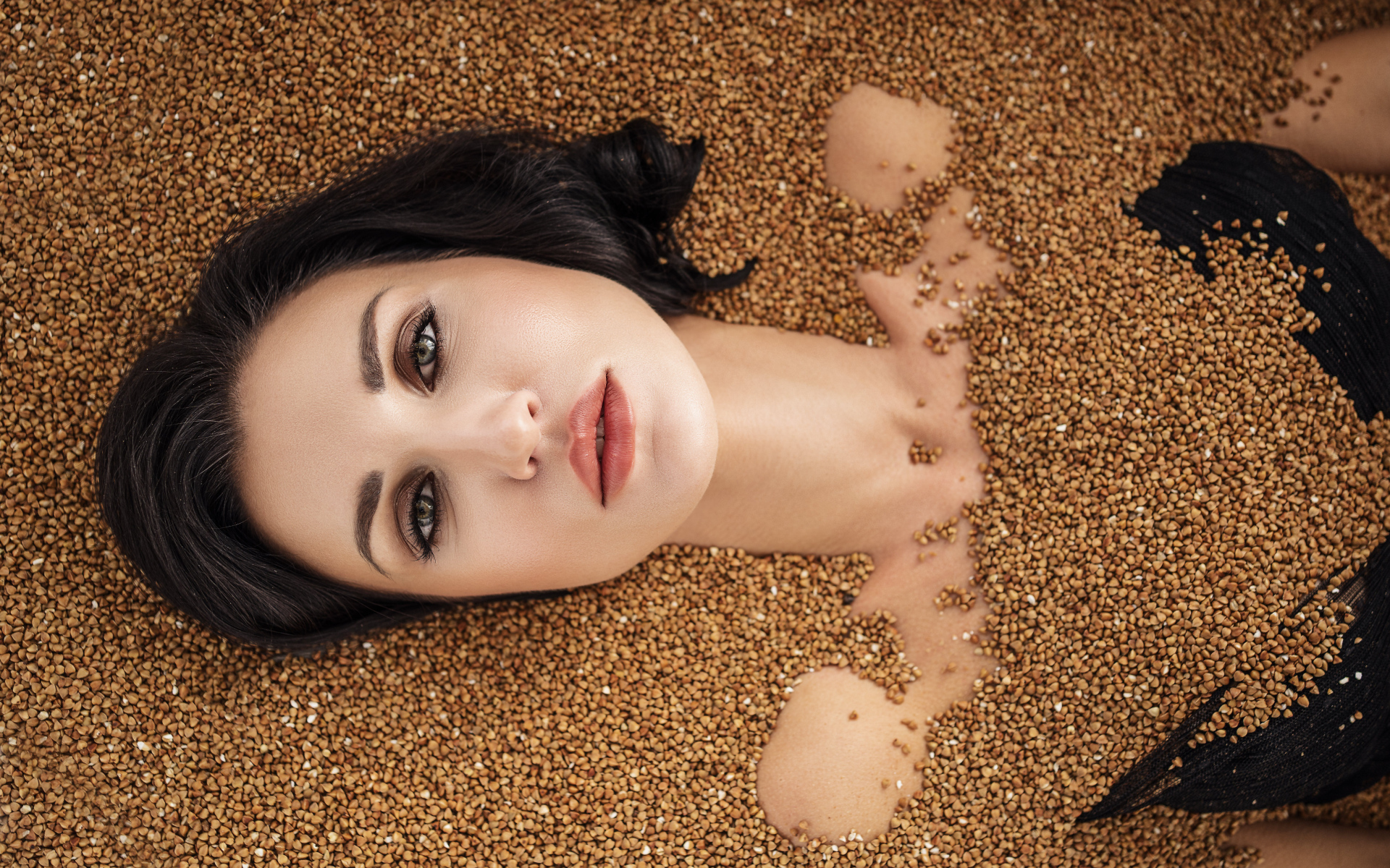 Красивая девушка лежит в зернах гречки