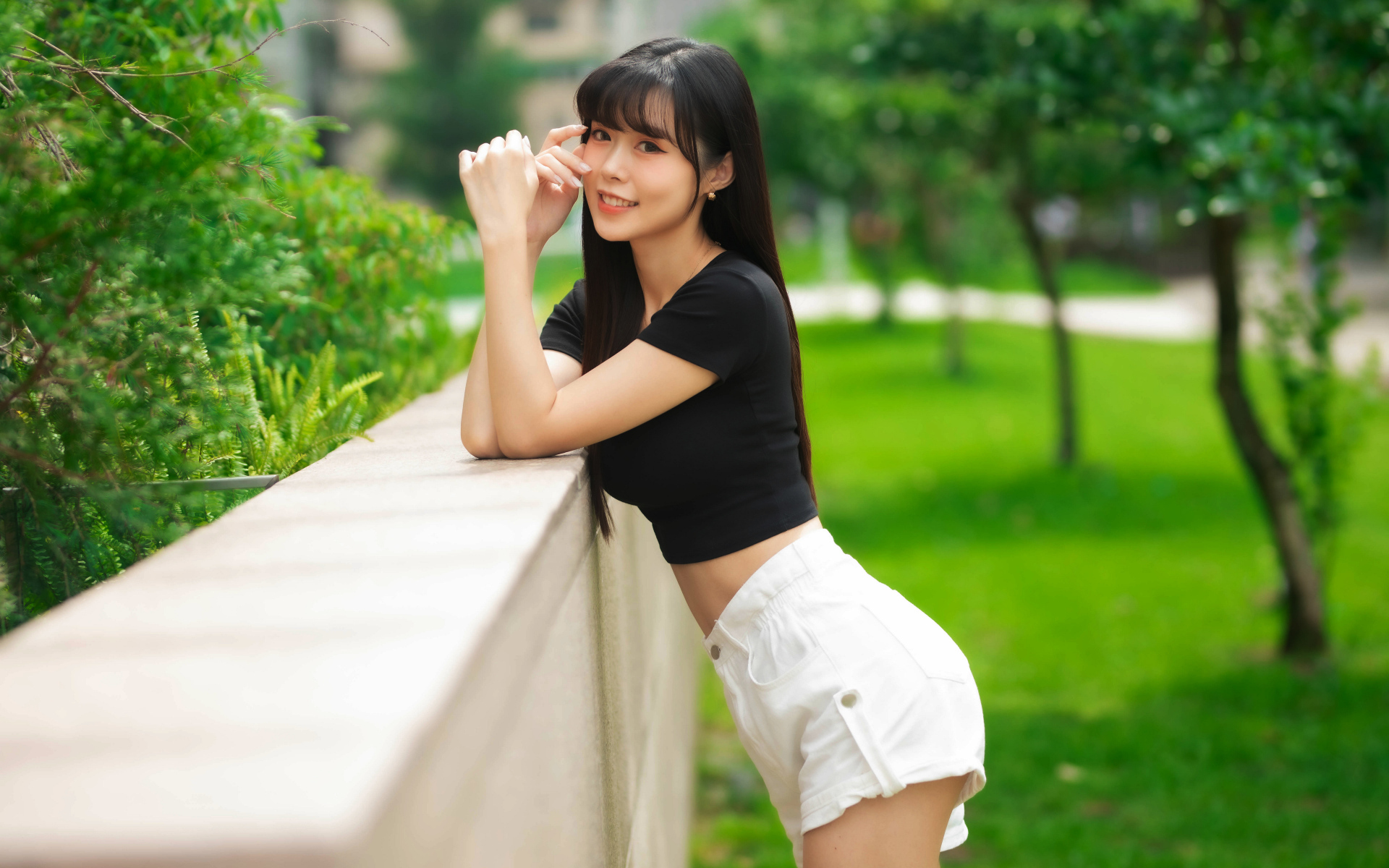 Молодая азиатка в белых шортах и футболке