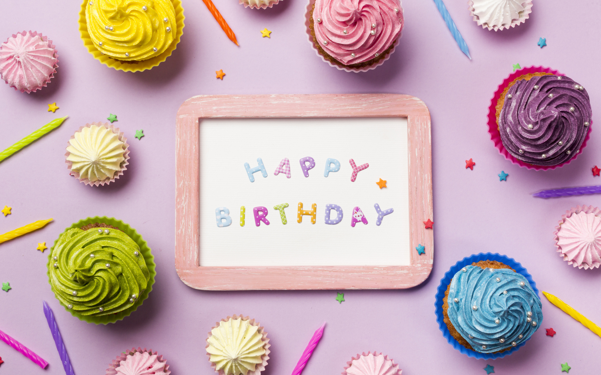 Открытка с днем рождения с кексами и свечами на розовом фоне