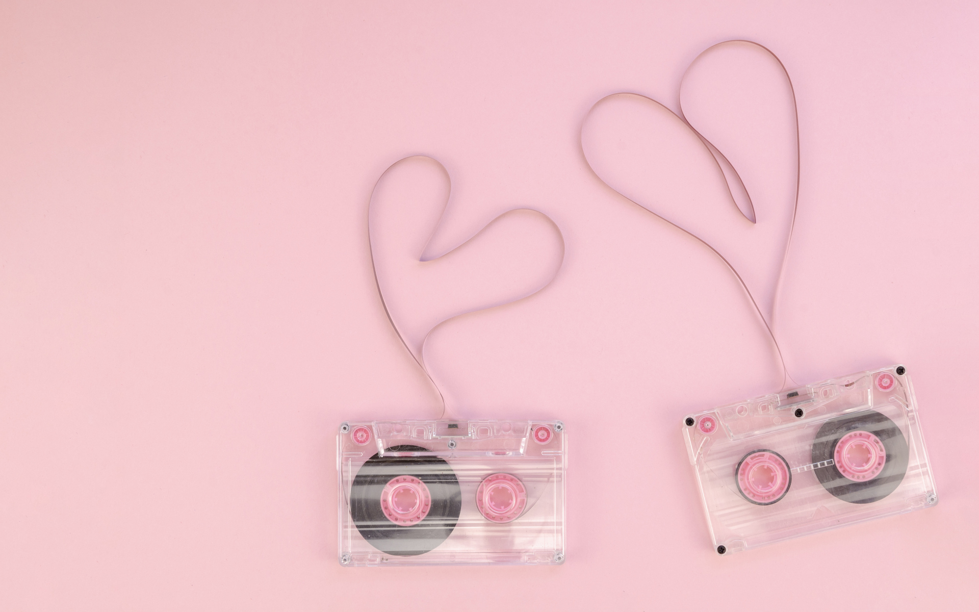 Сердечки из кассетной ленты на розовом фоне
