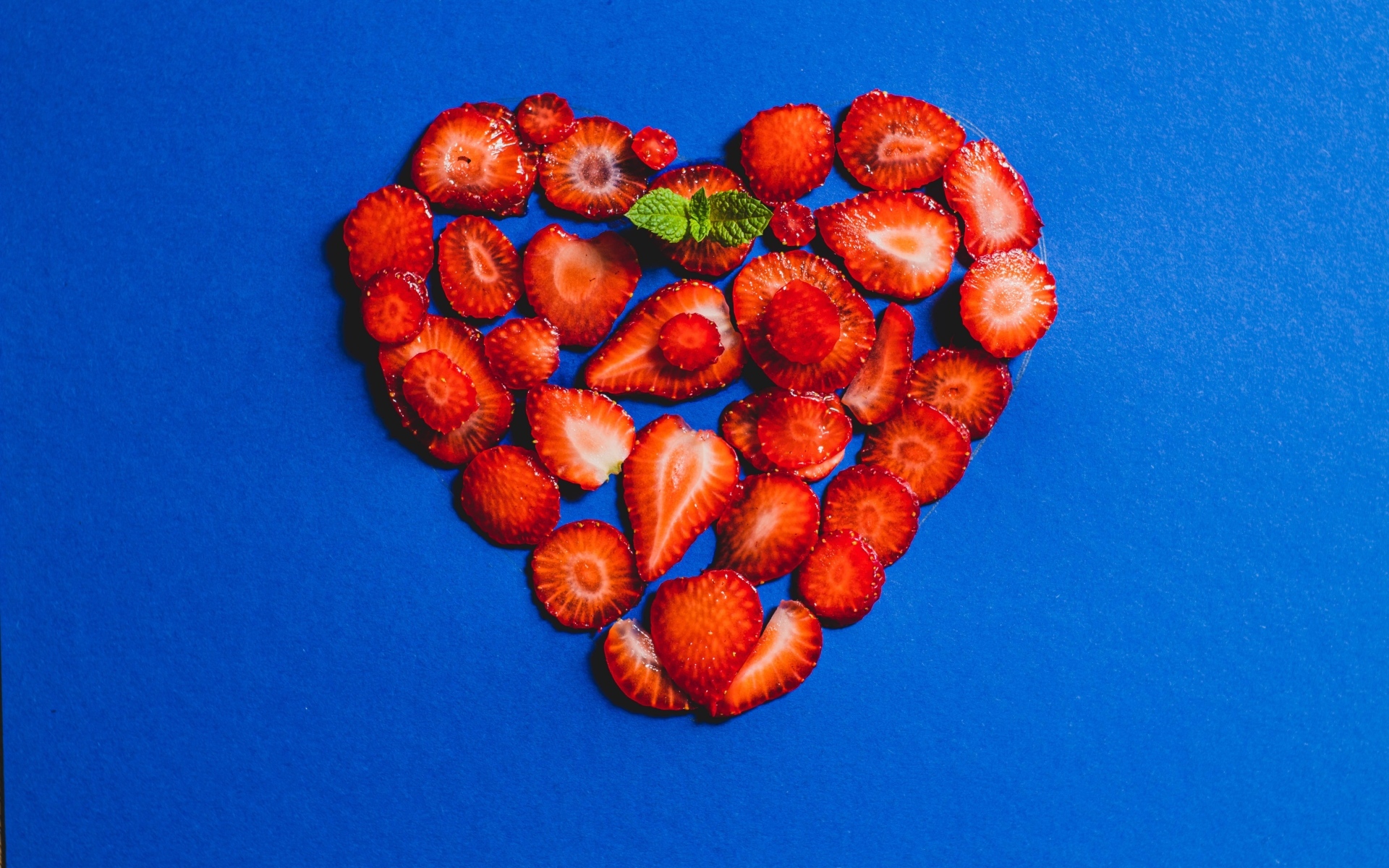 Сердце из сушеной клубники на синем фоне