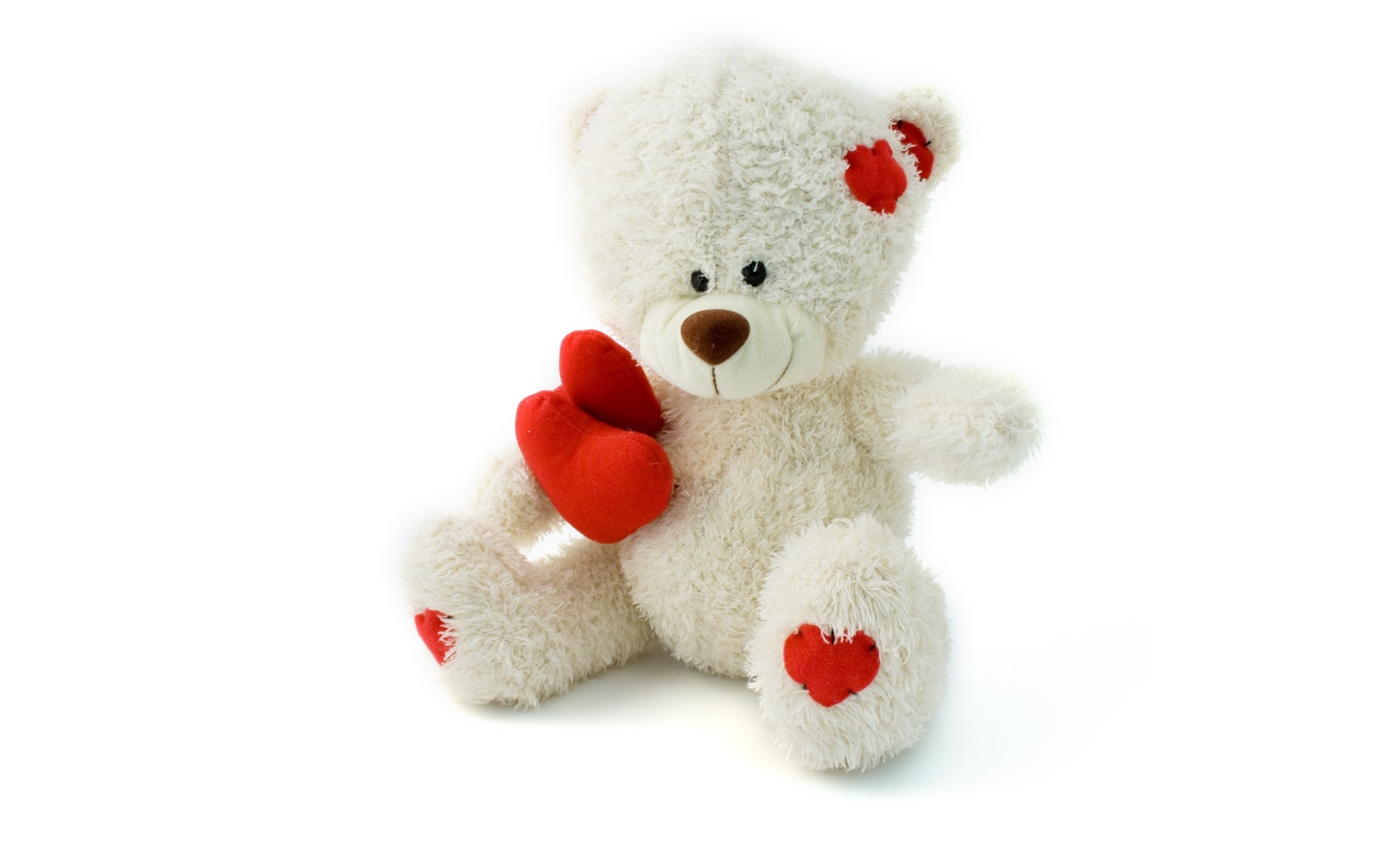 Белый плюшевый мишка с красным сердцем
