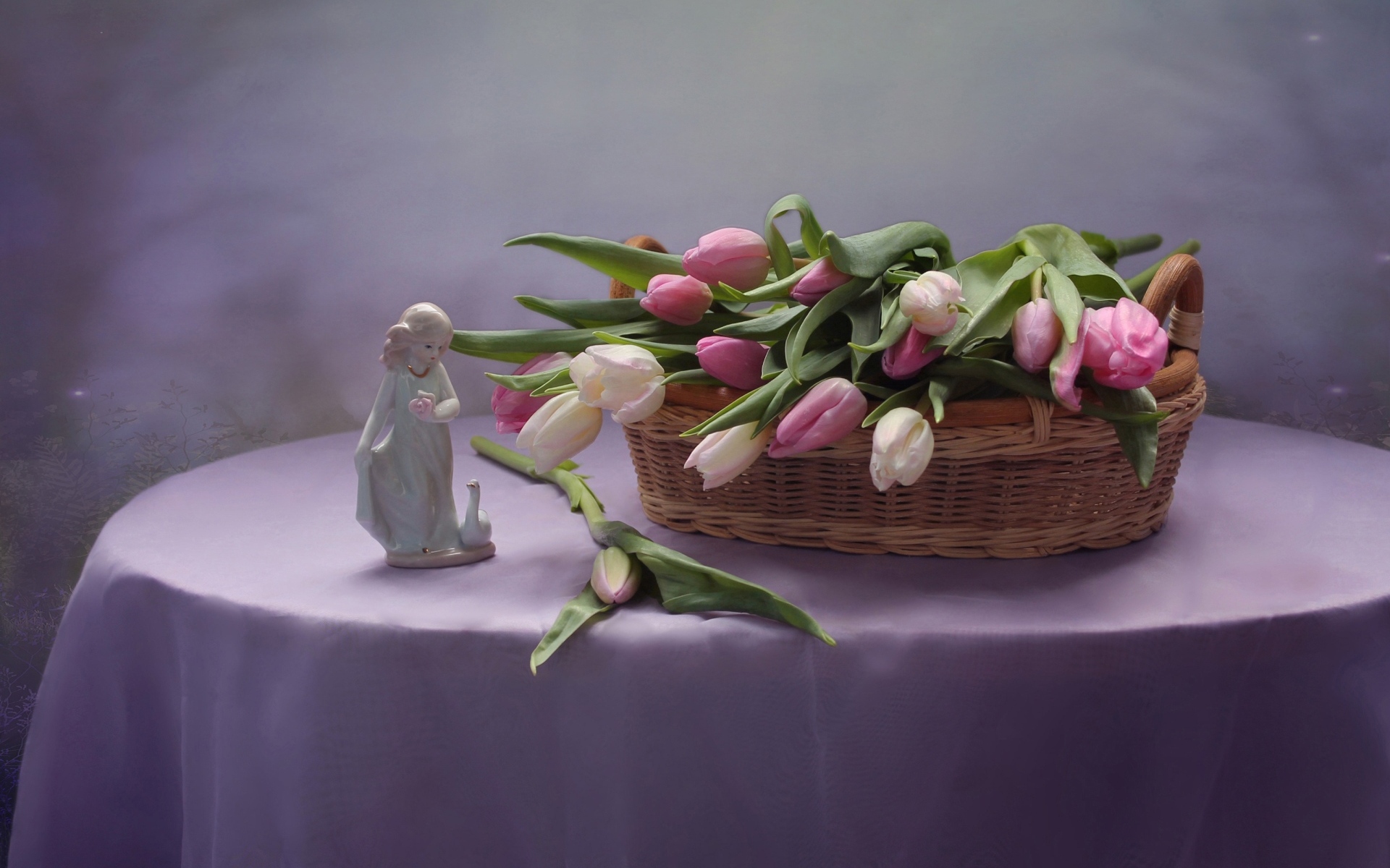 Корзина тюльпанов на столе со статуэткой