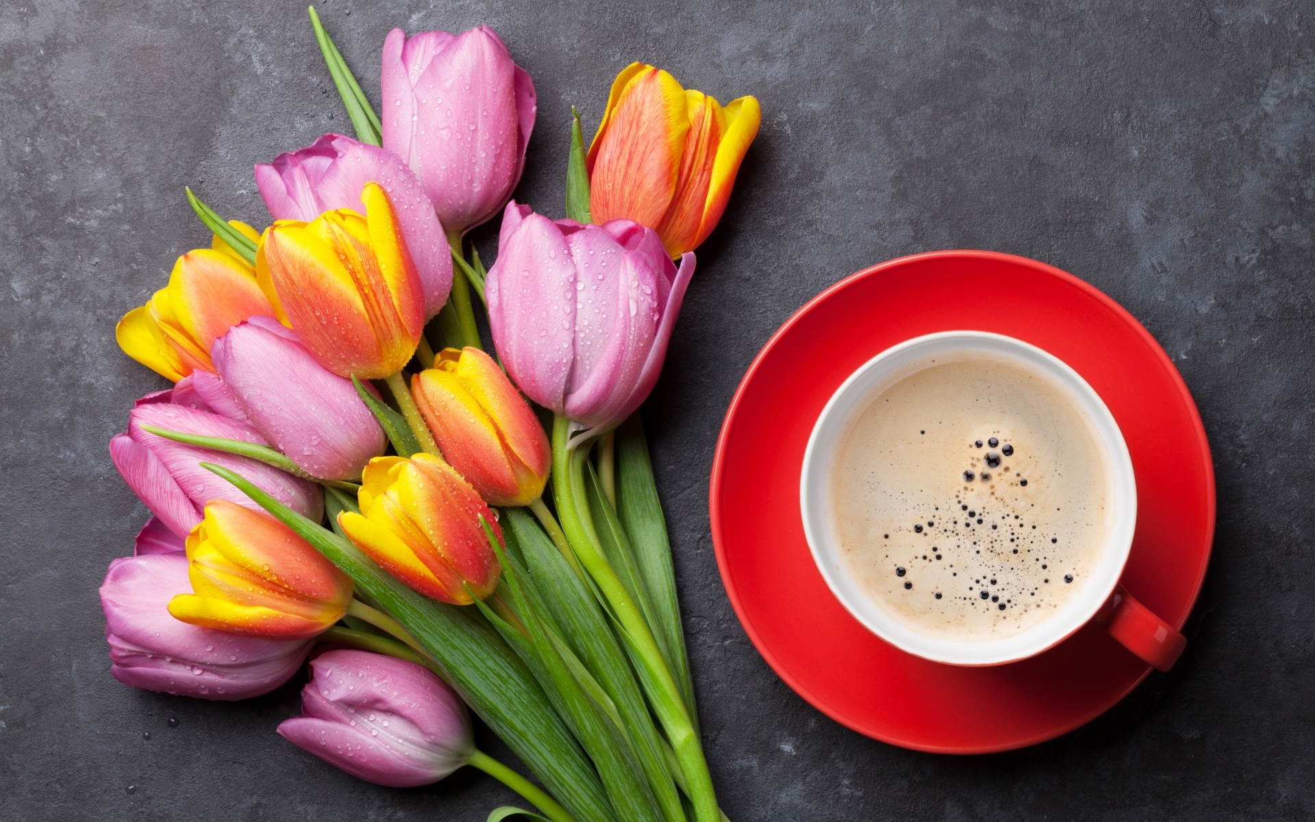 Букет разноцветных весенних тюльпанов на столе с чашкой кофе