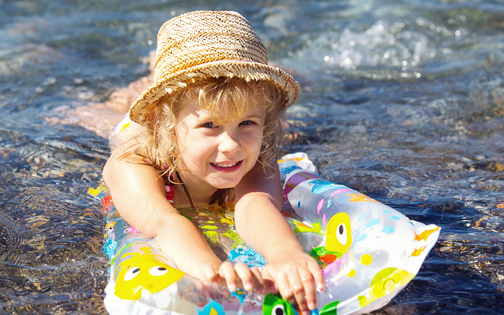 Девочка в шляпе плавает в воде