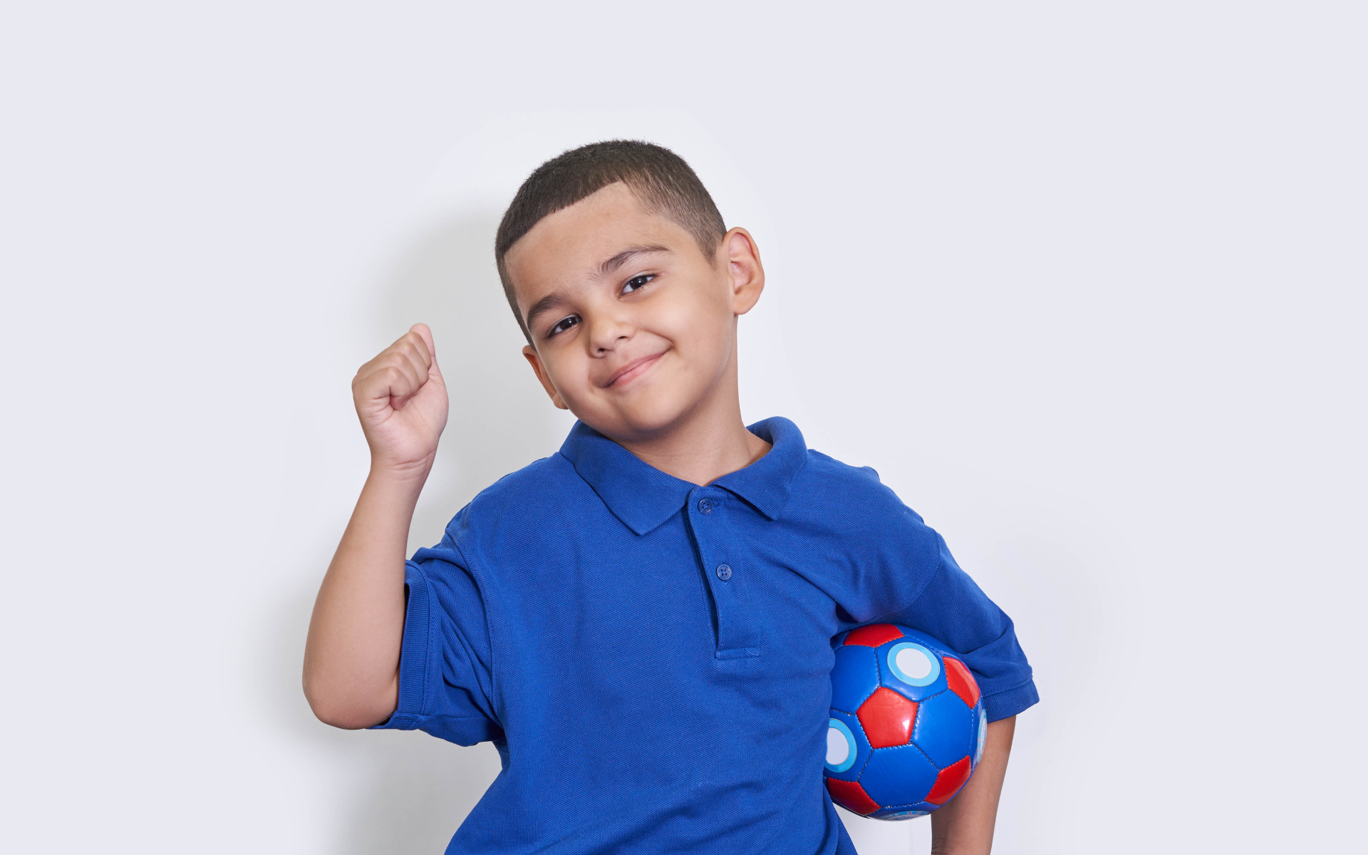 Милый мальчик с мячом на белом фоне