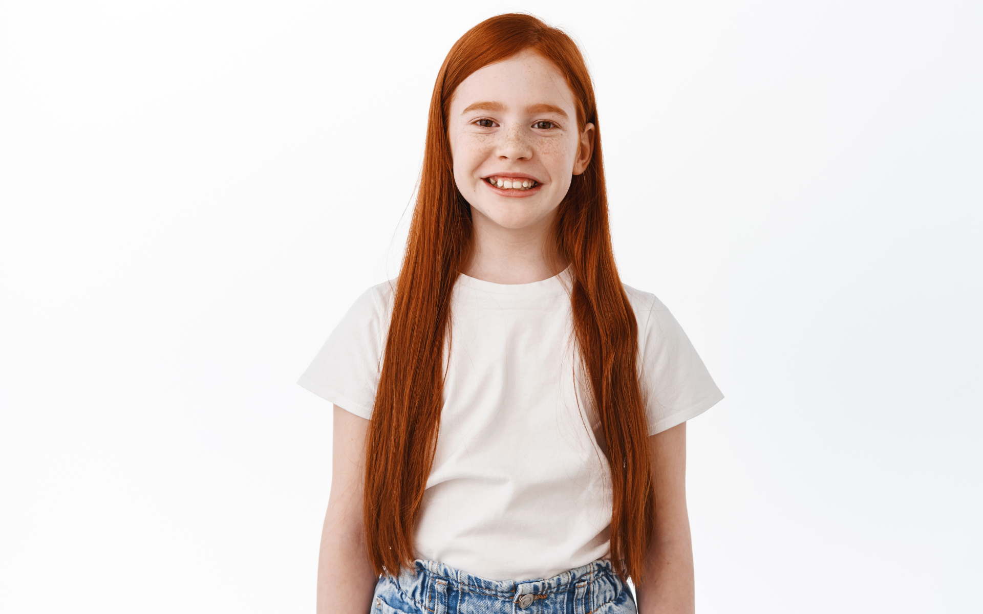 Улыбающаяся рыжеволосая девочка на белом фоне