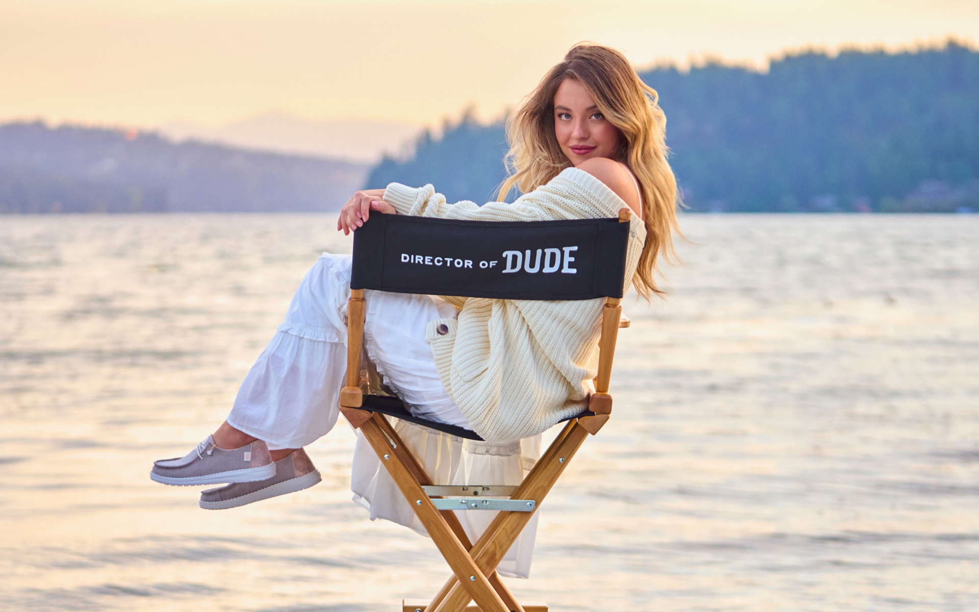 Актриса Сидни Суини сидит на стуле у озера