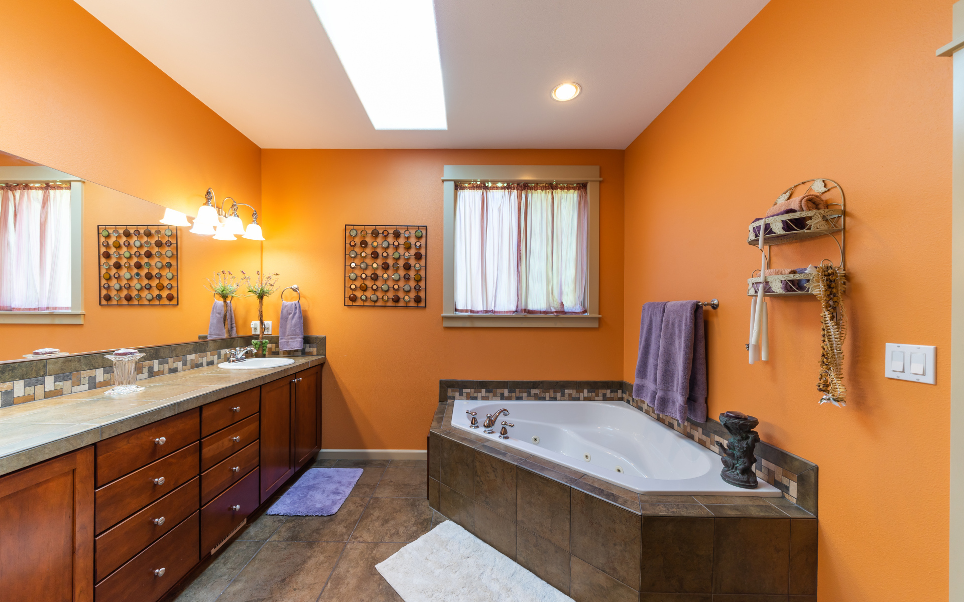 Интерьер ванной комнаты с большой ванной и стенами оранжевого цвета