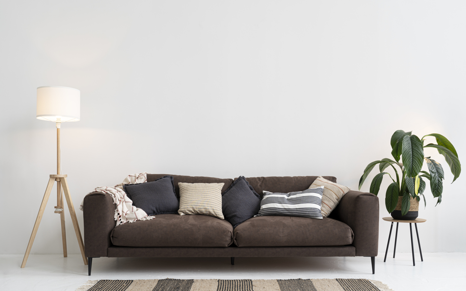 Коричневый диван у серой стены с лампой
