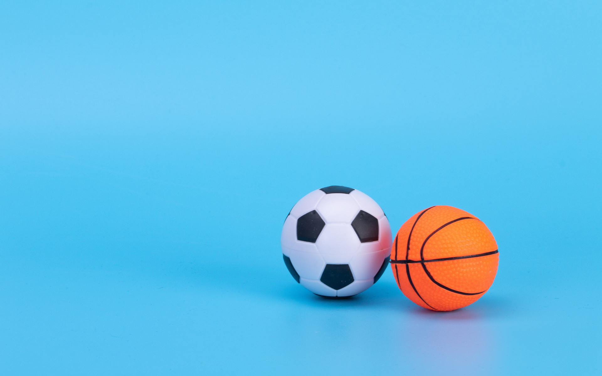 Футбольный и баскетбольный мяч на голубом фоне