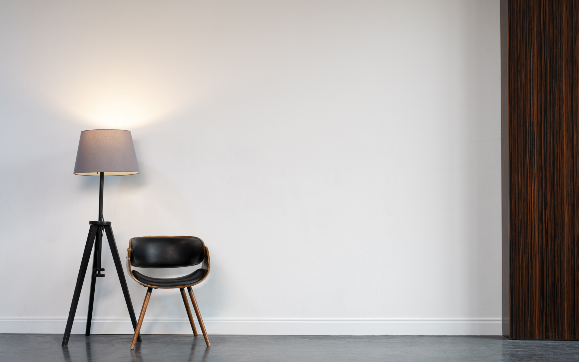 Кожаное кресло с торшером в пустой комнате