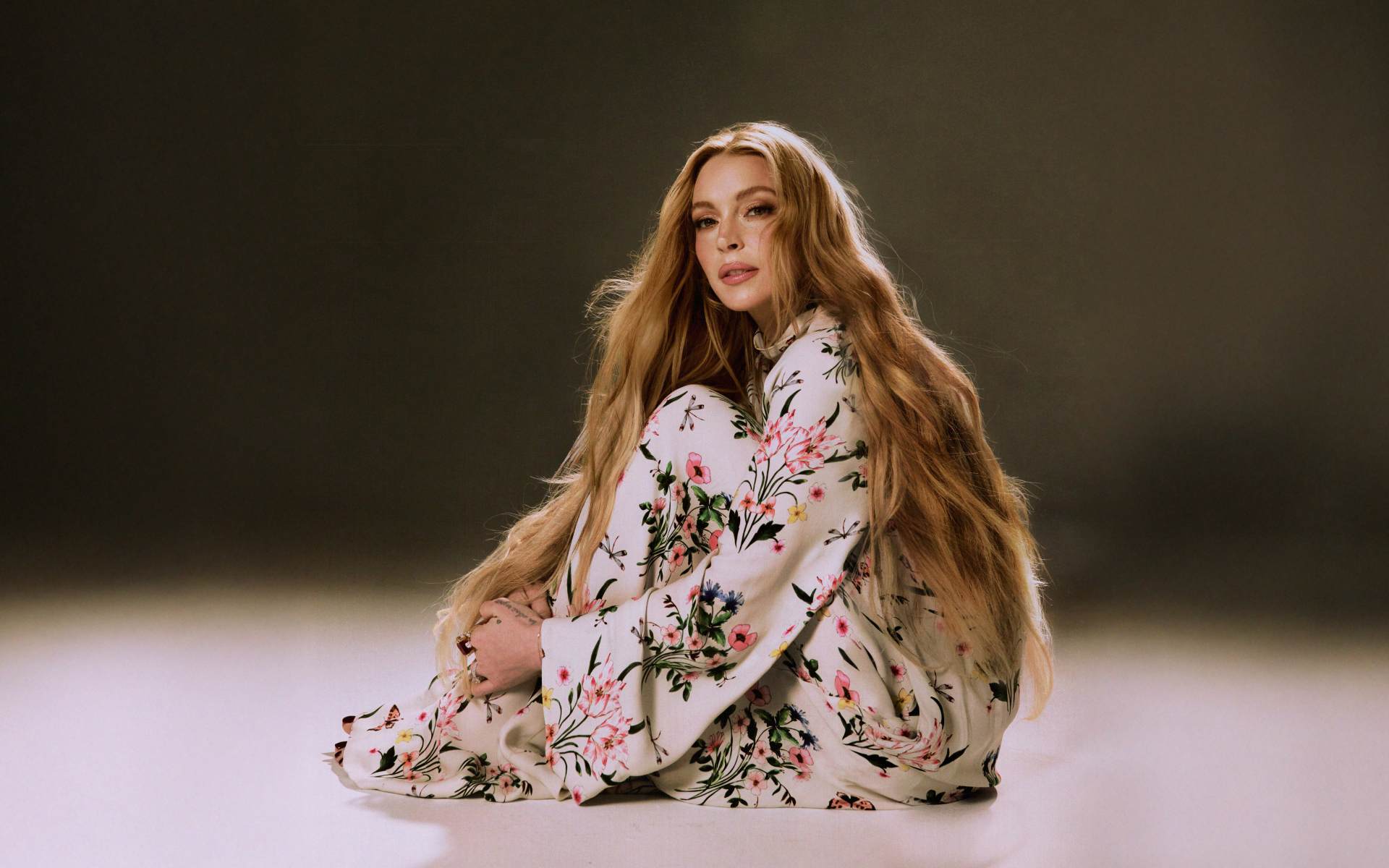 Популярная актриса Линдси Лохан в платье сидит на полу