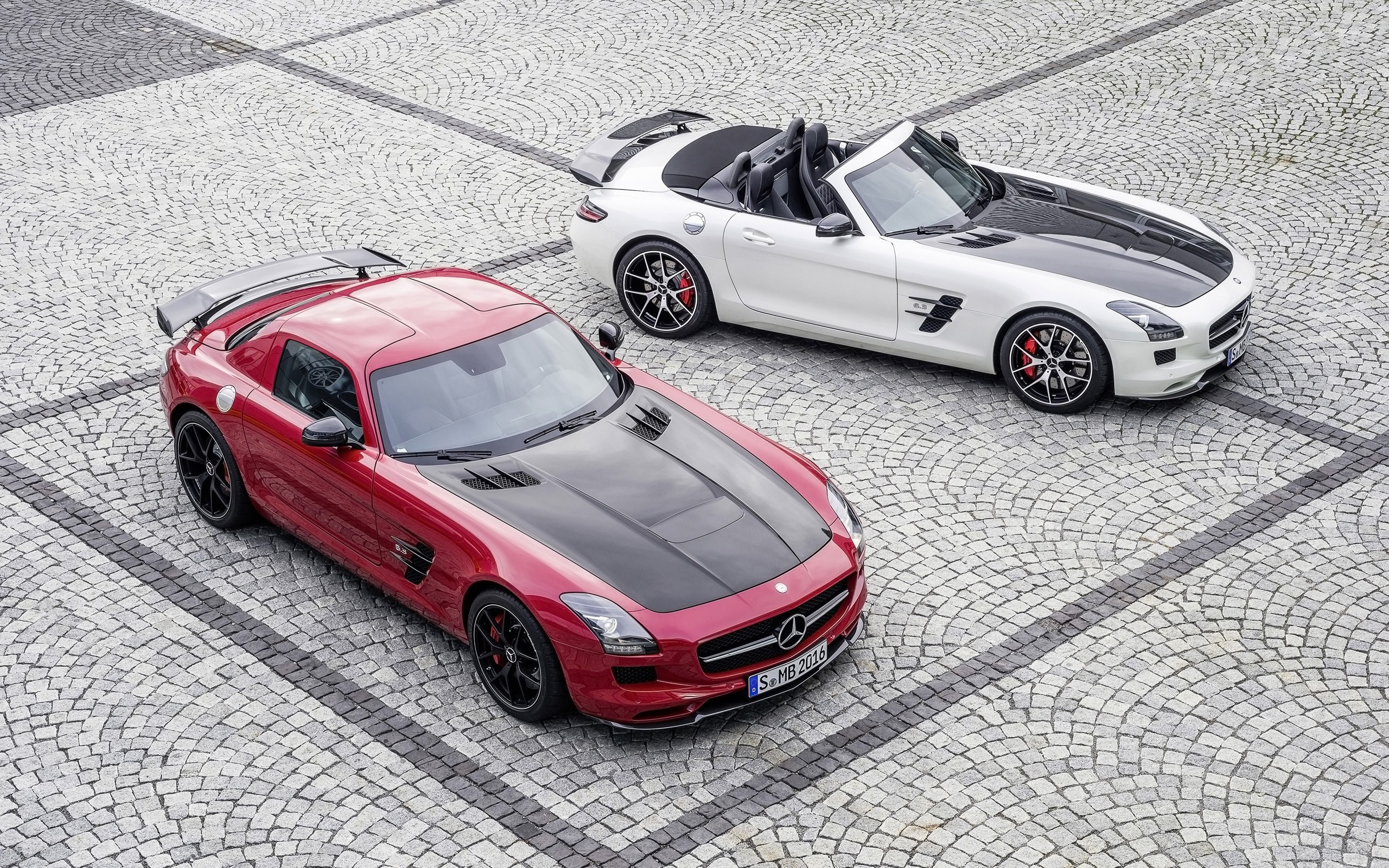 Красный и белый Mercedes-Benz SLS AMG на брусчатке