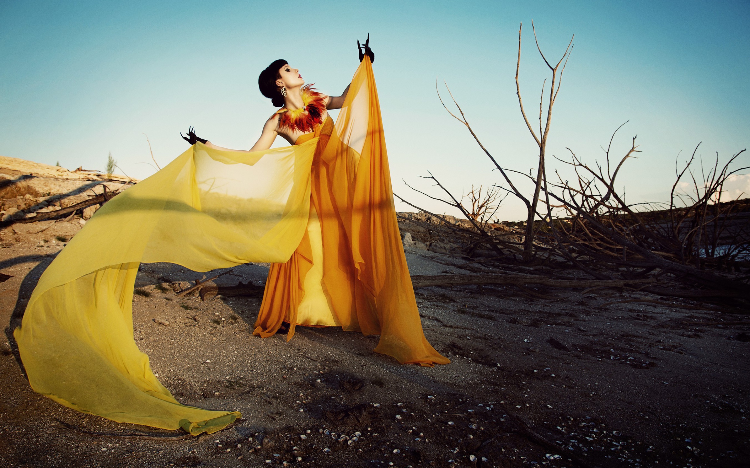 Девушка в оранжевом позирует в пустыне