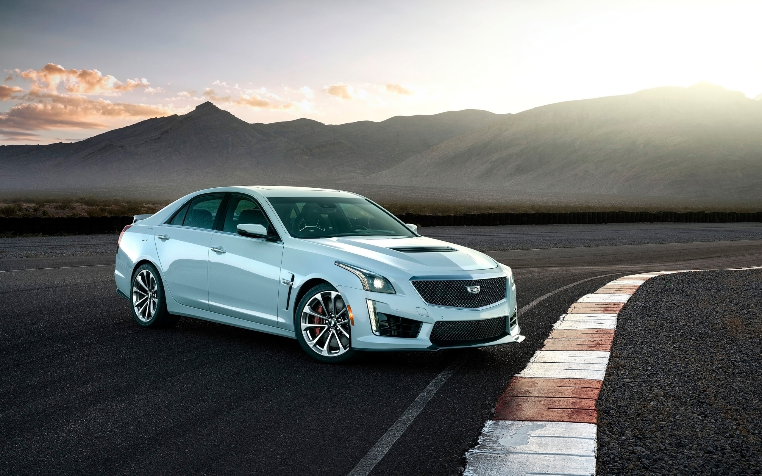 Белый автомобиль Cadillac CTS-V Glacier Metallic Edition, 2018 на фоне гор