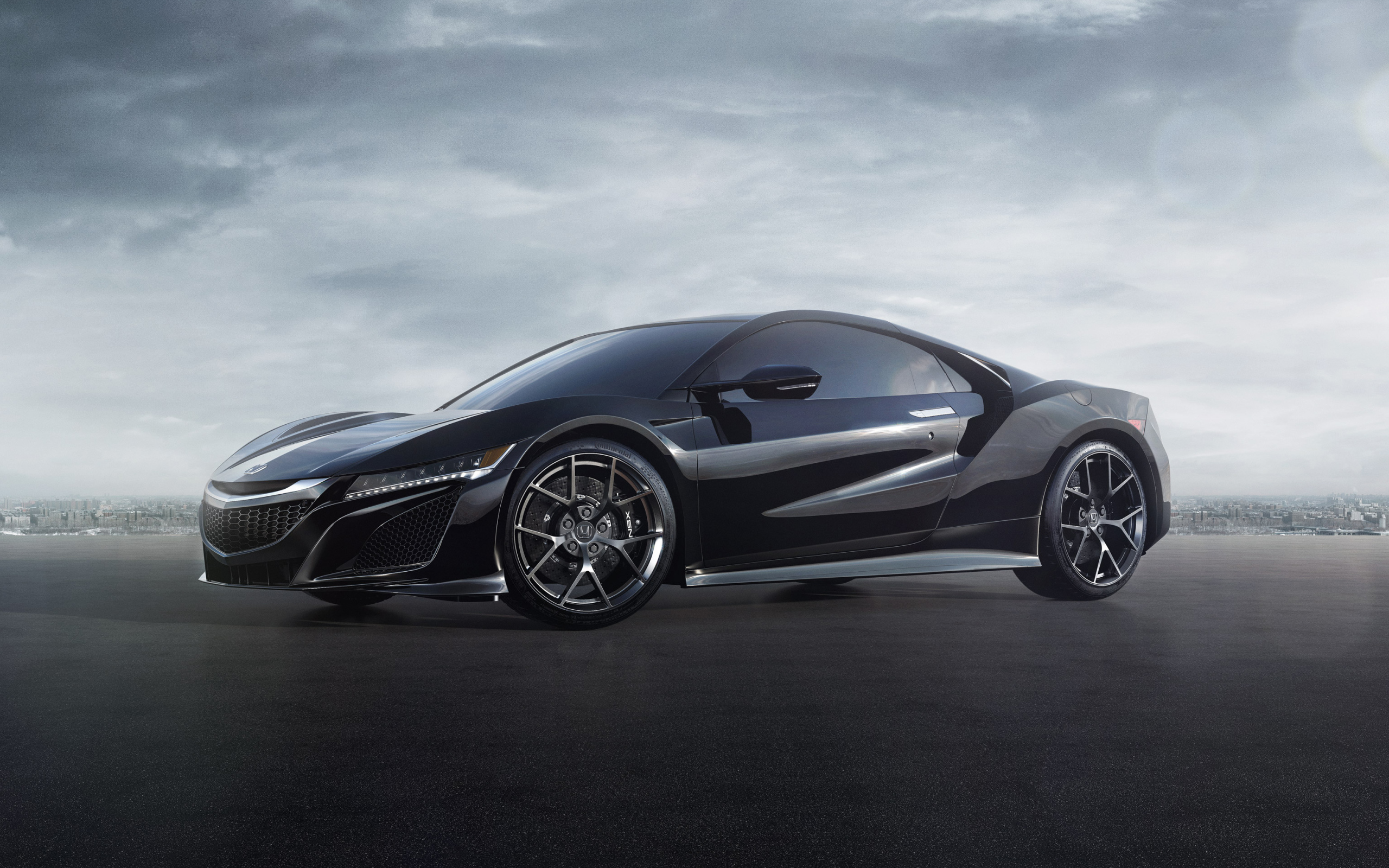 Черный спортивный автомобиль Honda NSX под пасмурным небом