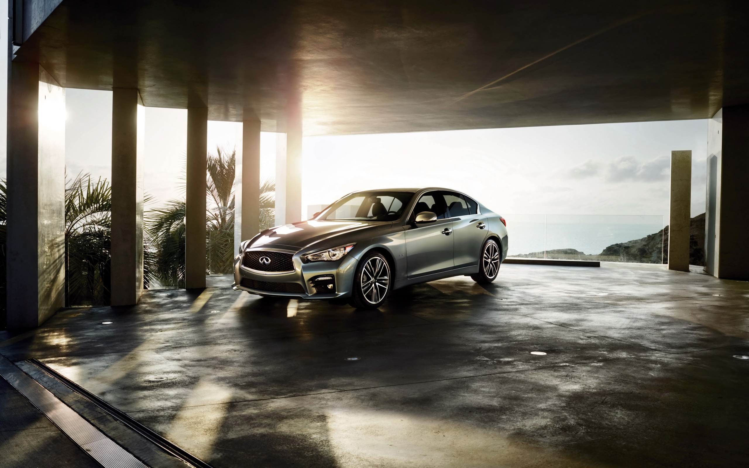 Серебристый автомобиль Infiniti Q50 в лучах солнца 