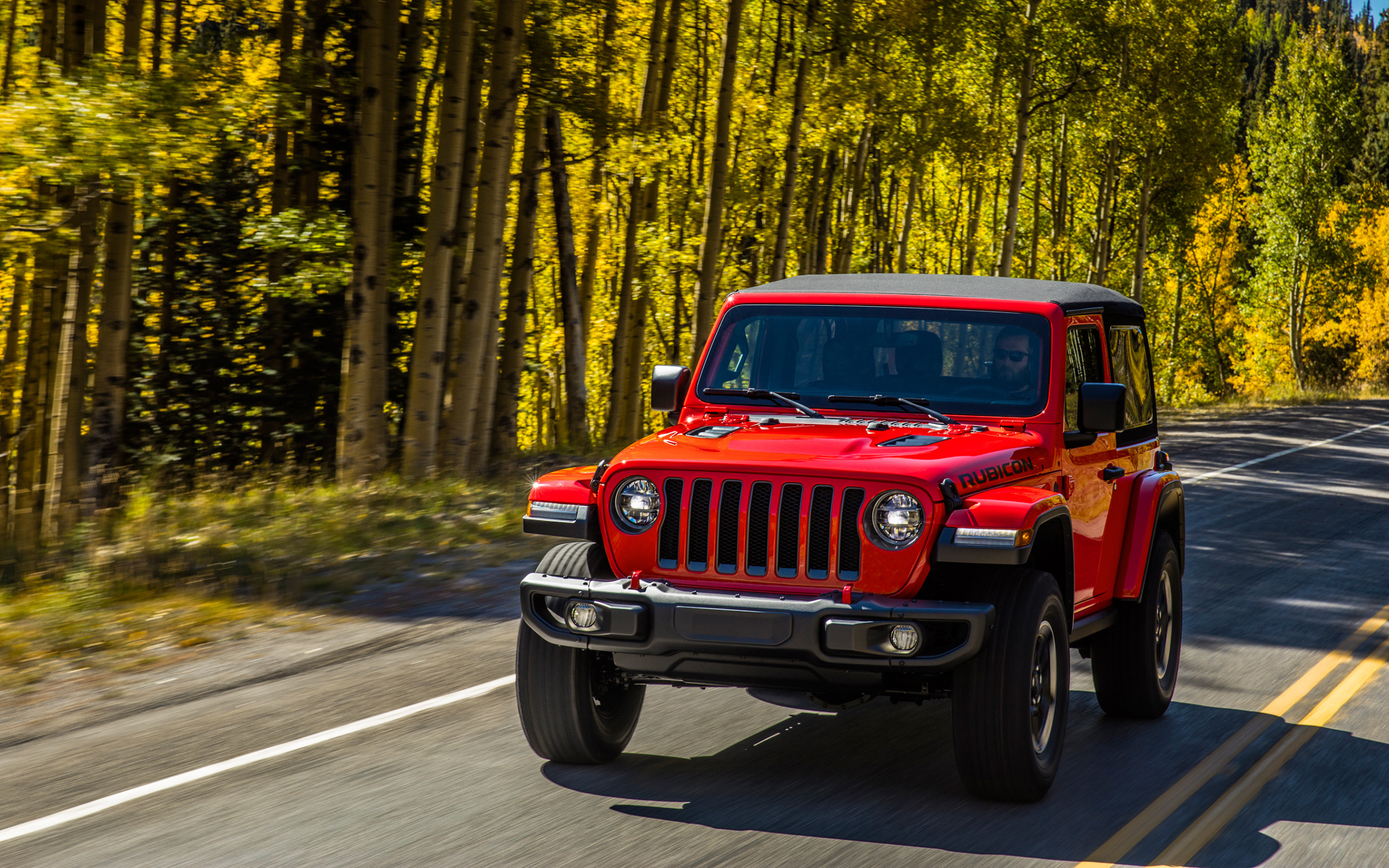 Красный автомобиль Jeep Wrangler Rubicon 2, 2018 на лесной трассе