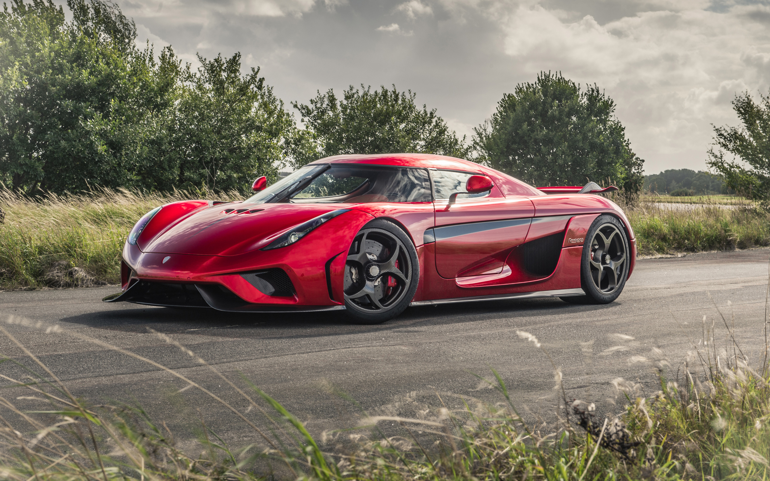 Красный спортивный автомобиль Koenigsegg Regera на дороге