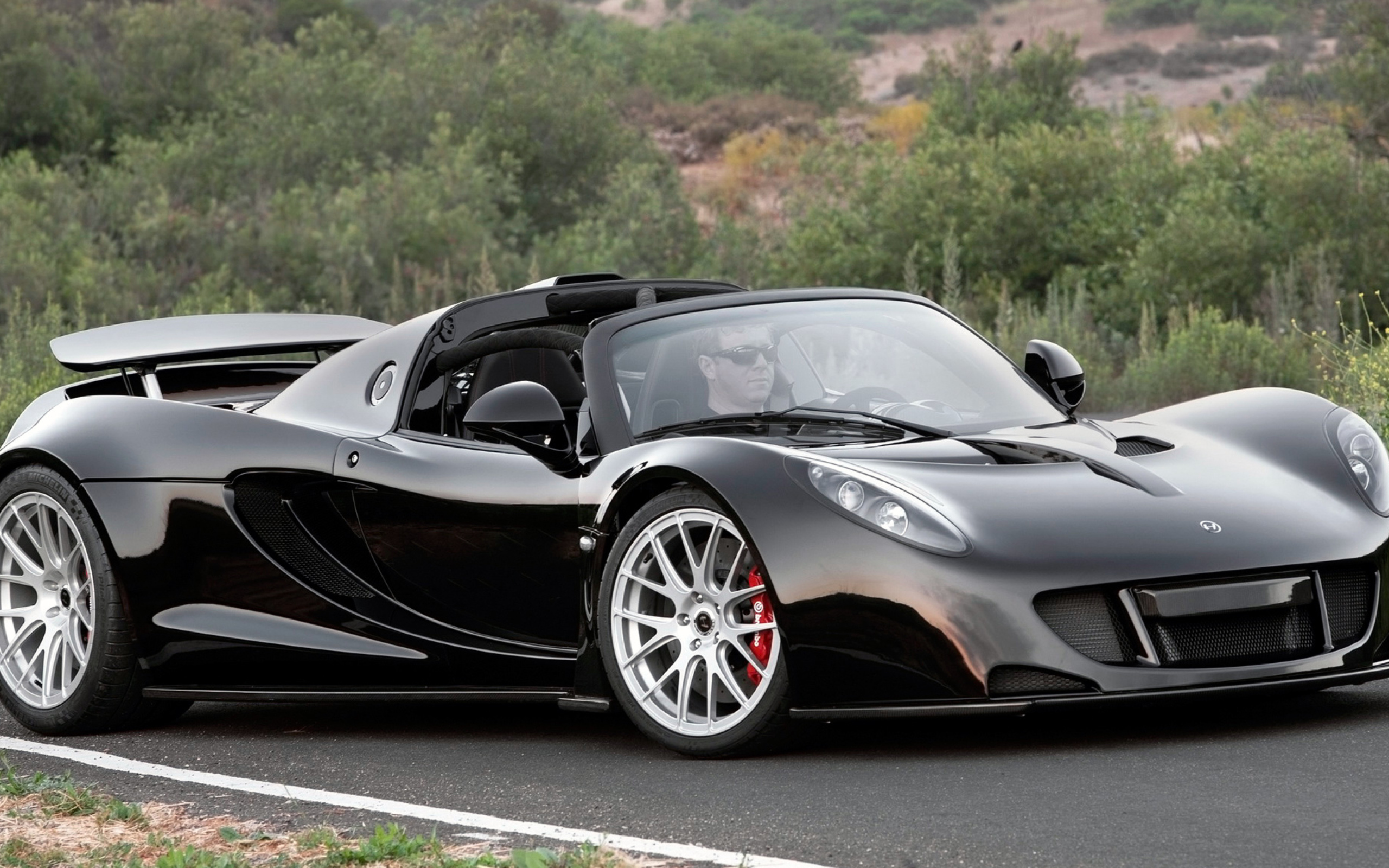 Черный спортивный суперкар Hennessey Venom GT на трассе