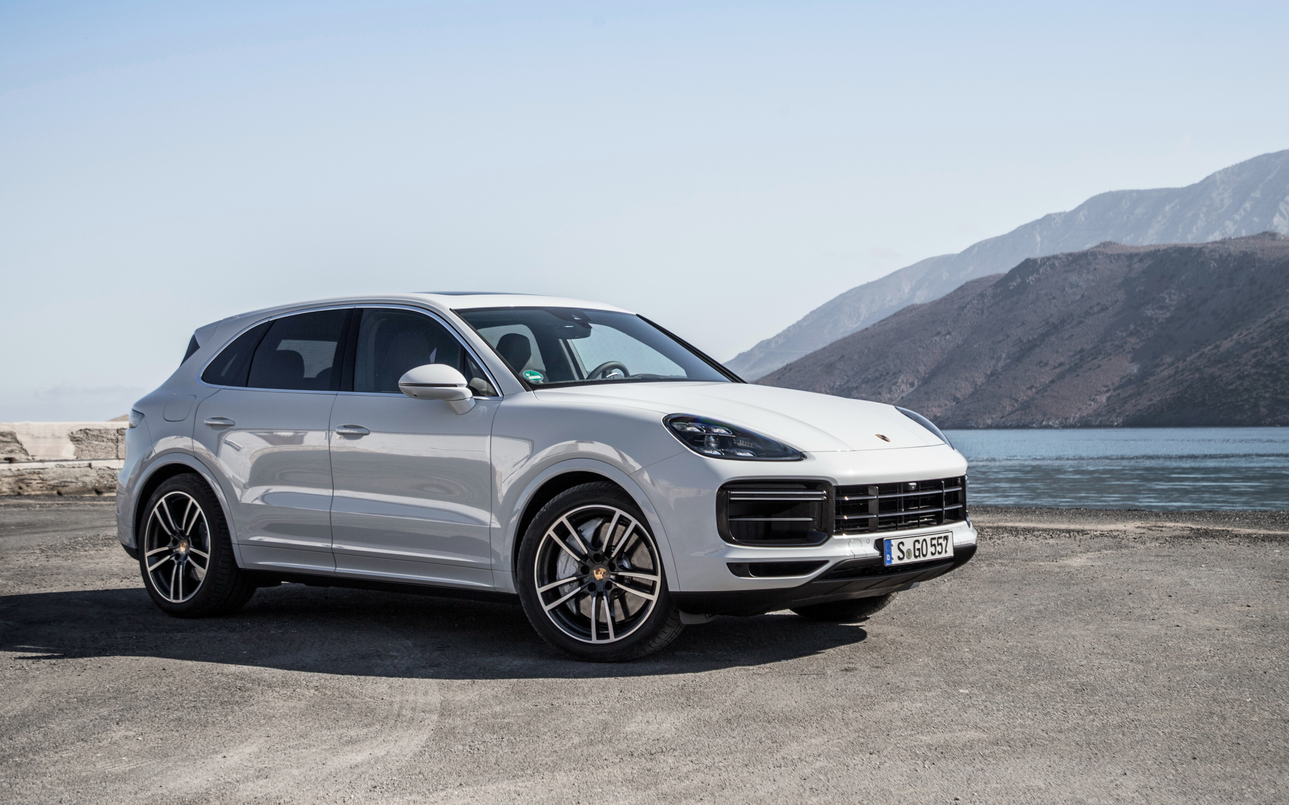 Белый автомобиль Porsche Cayenne Turbo, 2018 у воды