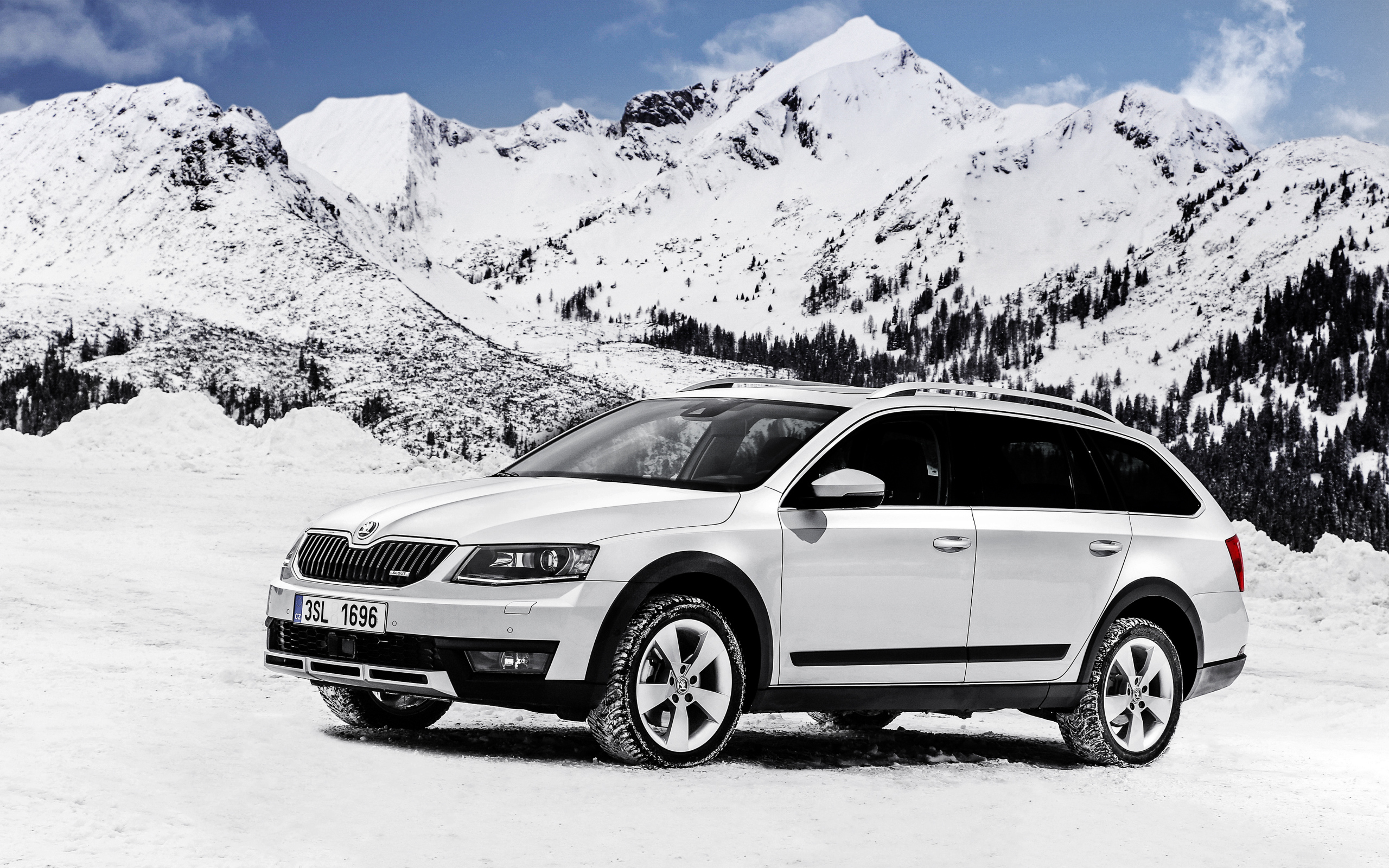 Белый автомобиль Skoda Octavia на фоне заснеженных гор
