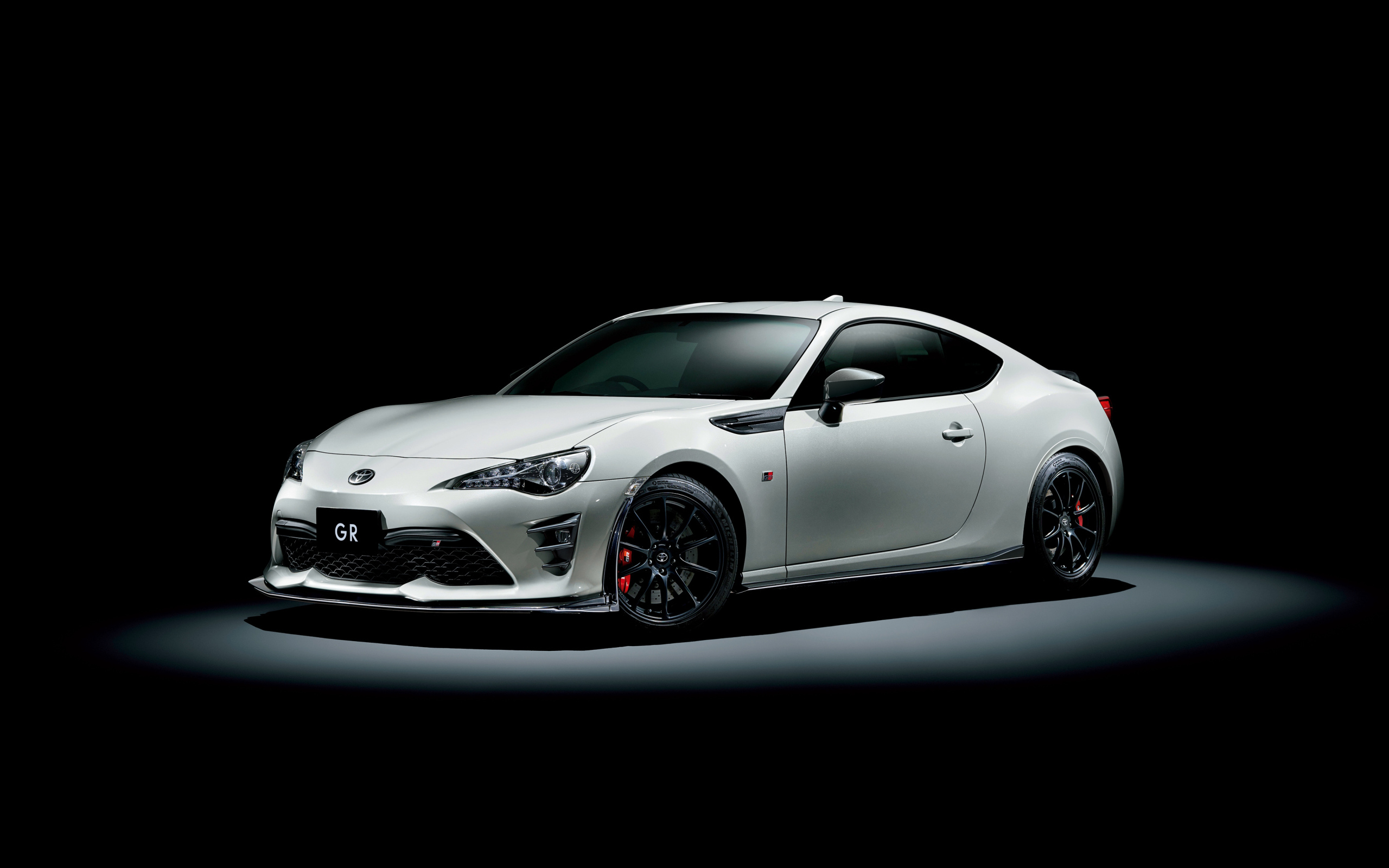 Белый спортивный автомобиль Toyota 86 GR на черном фоне