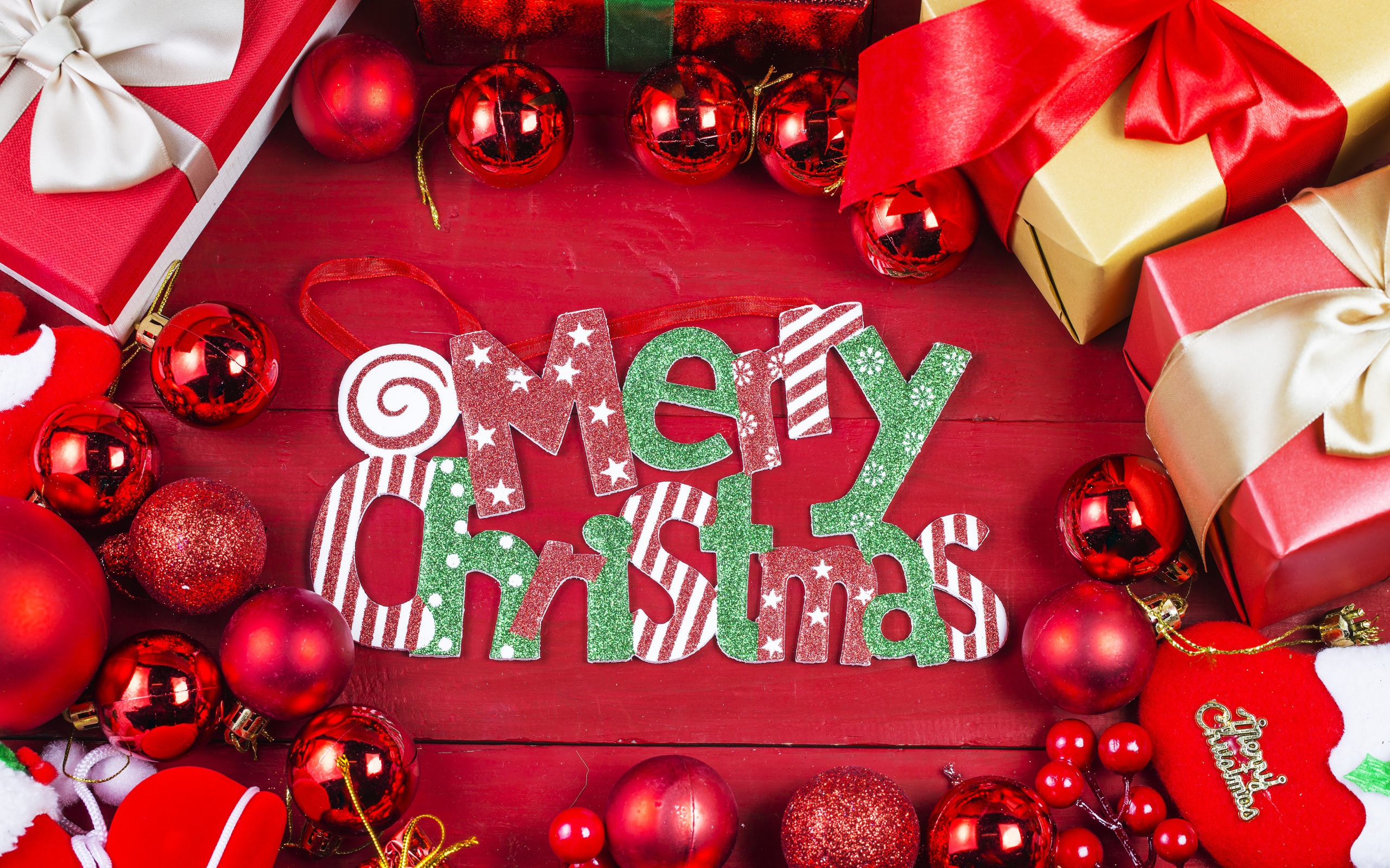 Merry Christmas holiday inscription on a red background with toys and gifts