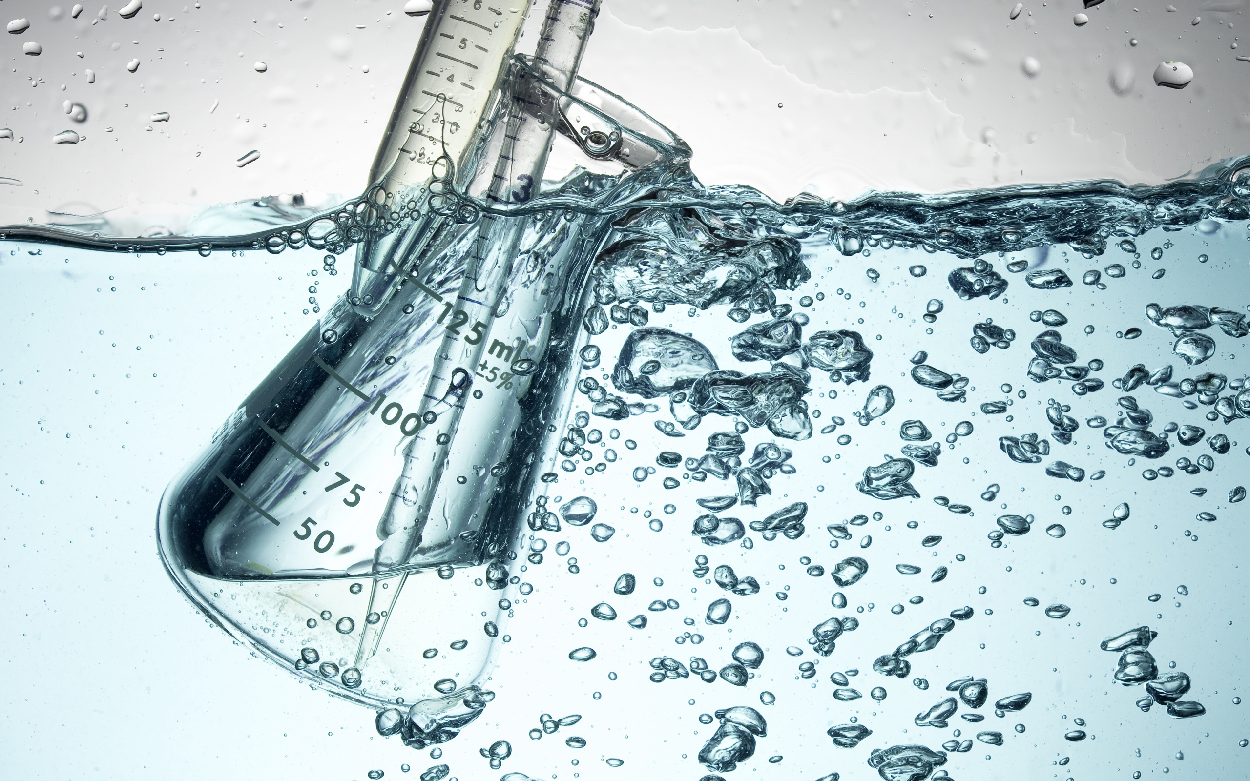 Измерительная чашка в воде с пузырями 