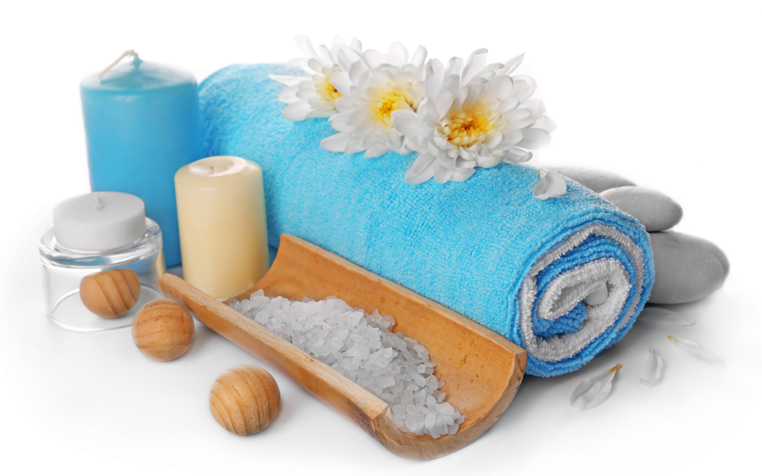 Полотенце, свечи, соль и цветы хризантемы на белом фоне