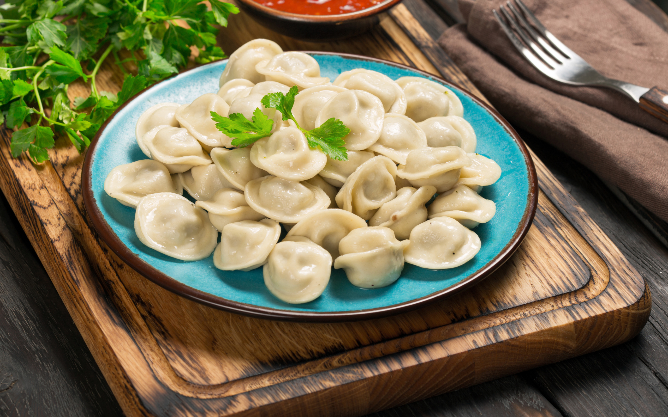 Вкусные пельмени на голубой тарелке 