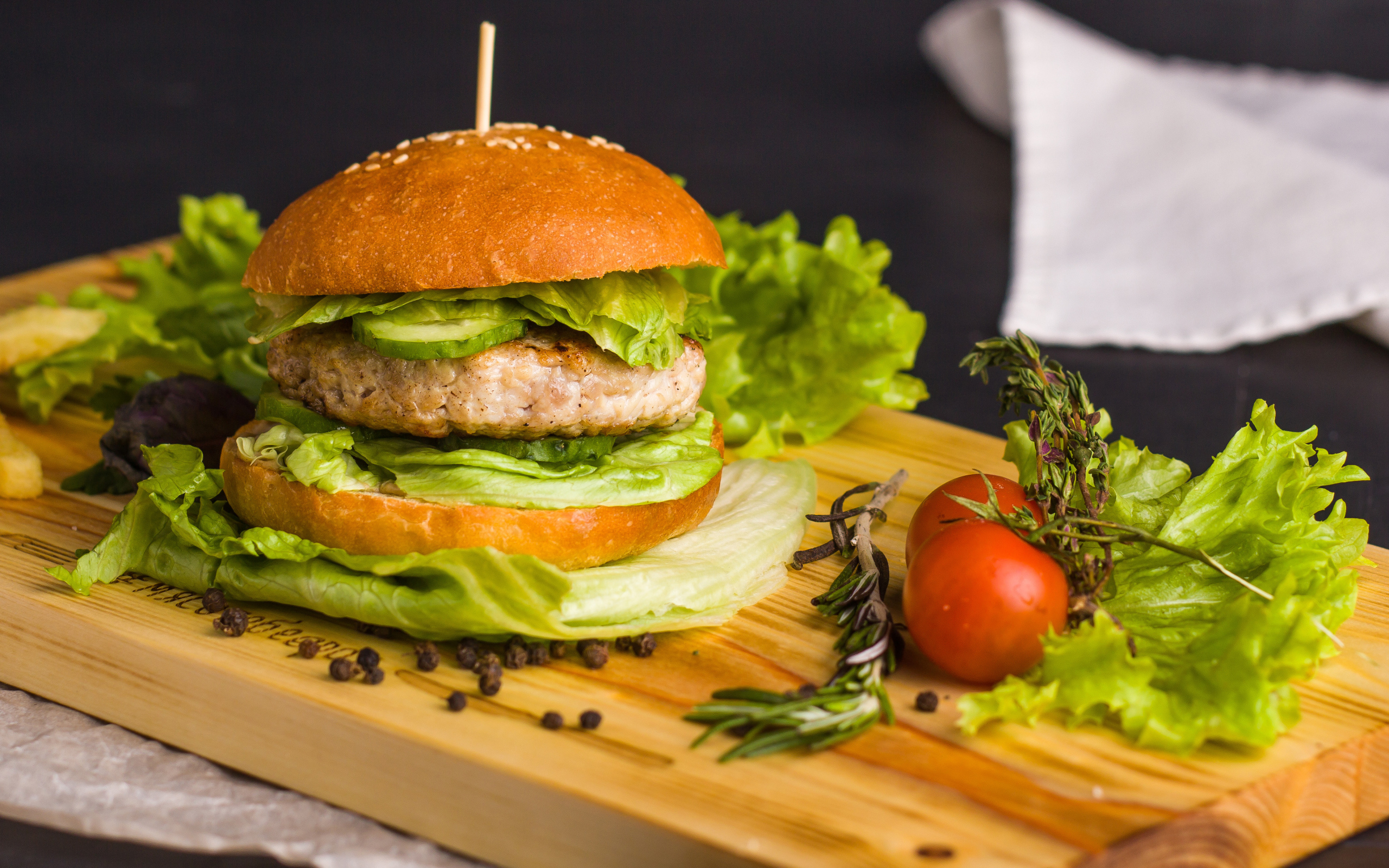 Гамбургер с зеленью на разделочной доске  