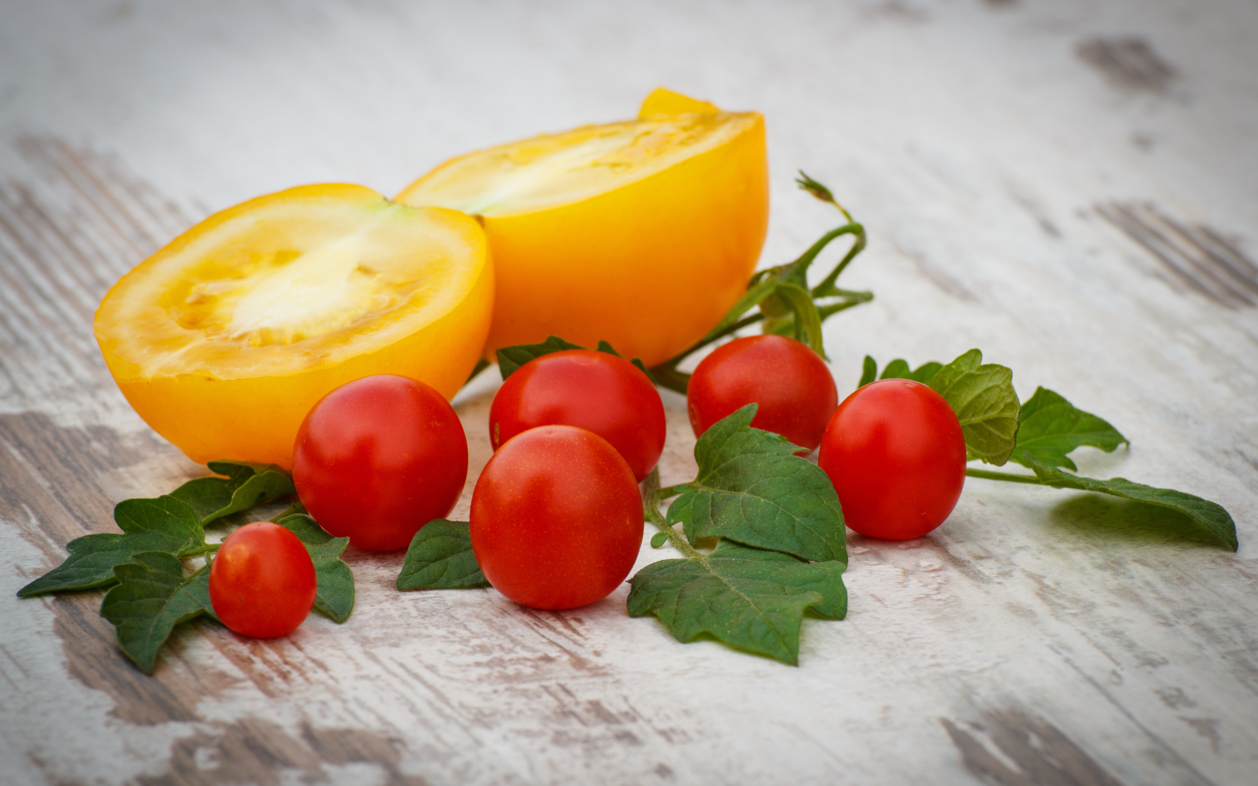 Желтые и красные помидоры на деревянной доске