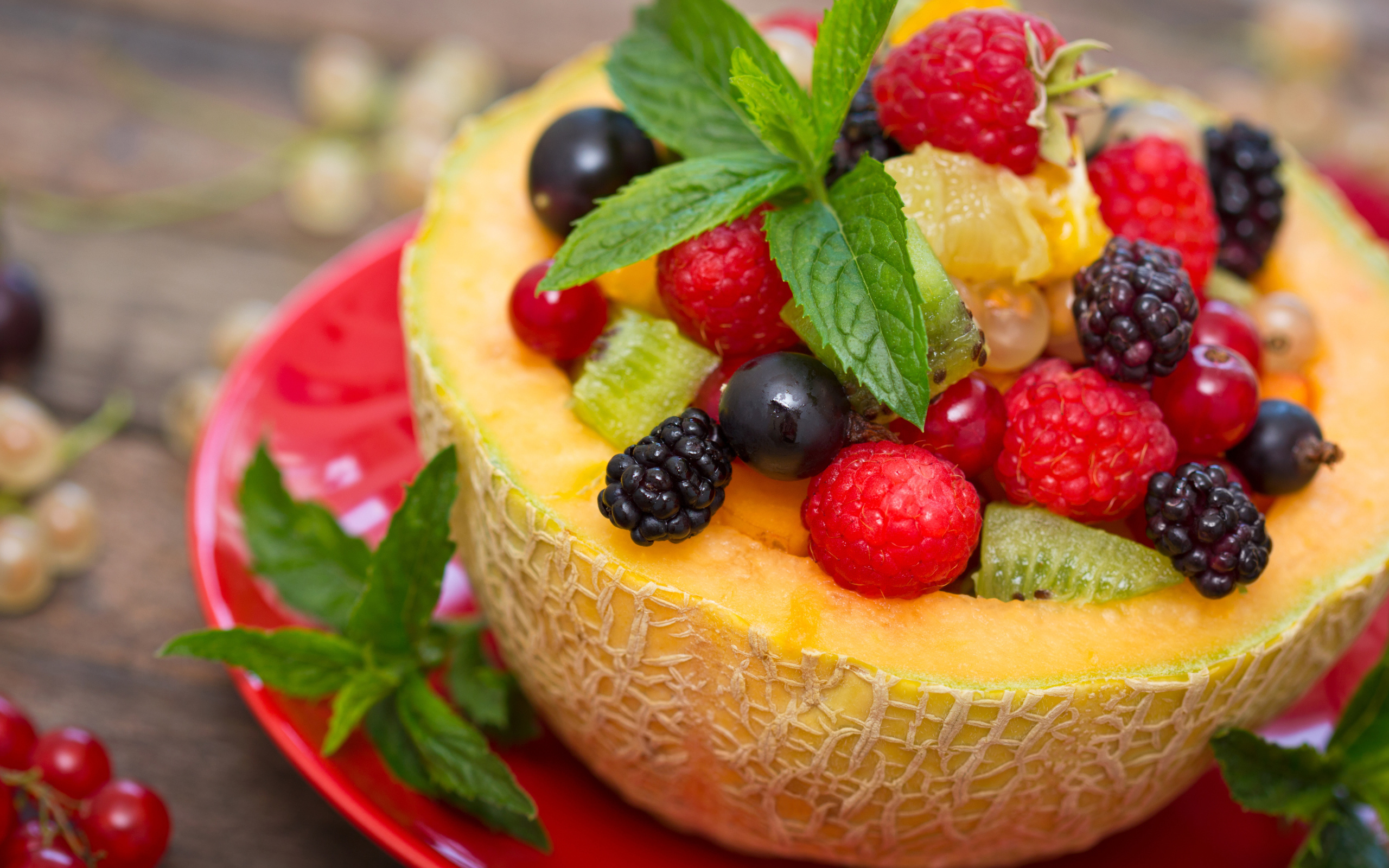 Аппетитные свежие ягоды с листьями мяты в половине дыни