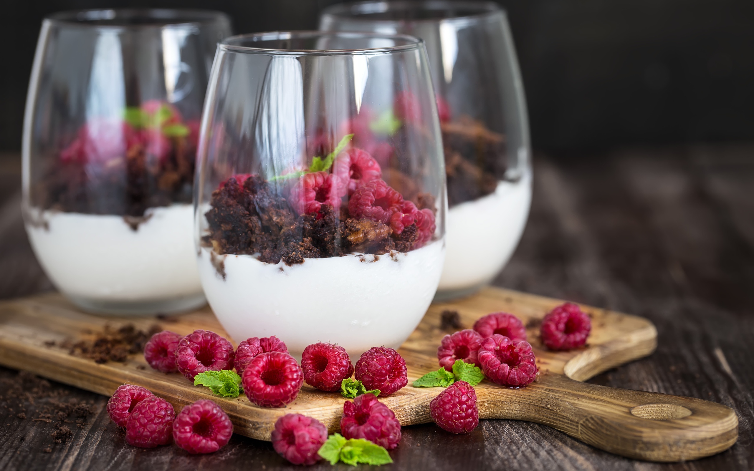 Десерт со сливками, шоколадом и свежей малиной в стеклянных стаканах