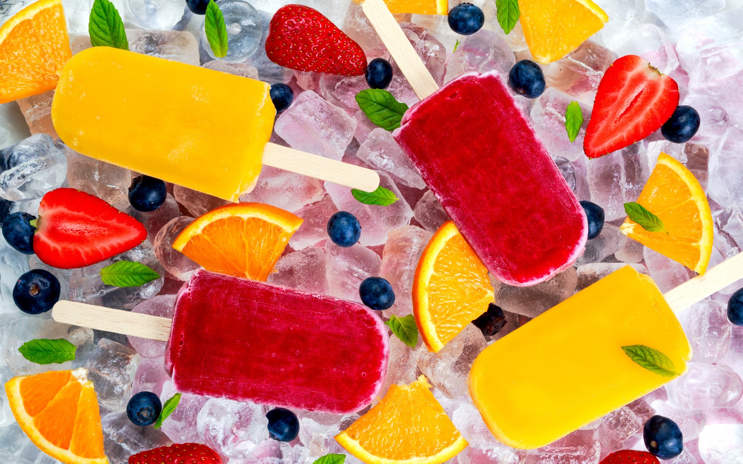 Multicolored fruit ice cream with berries lies on ice pieces 