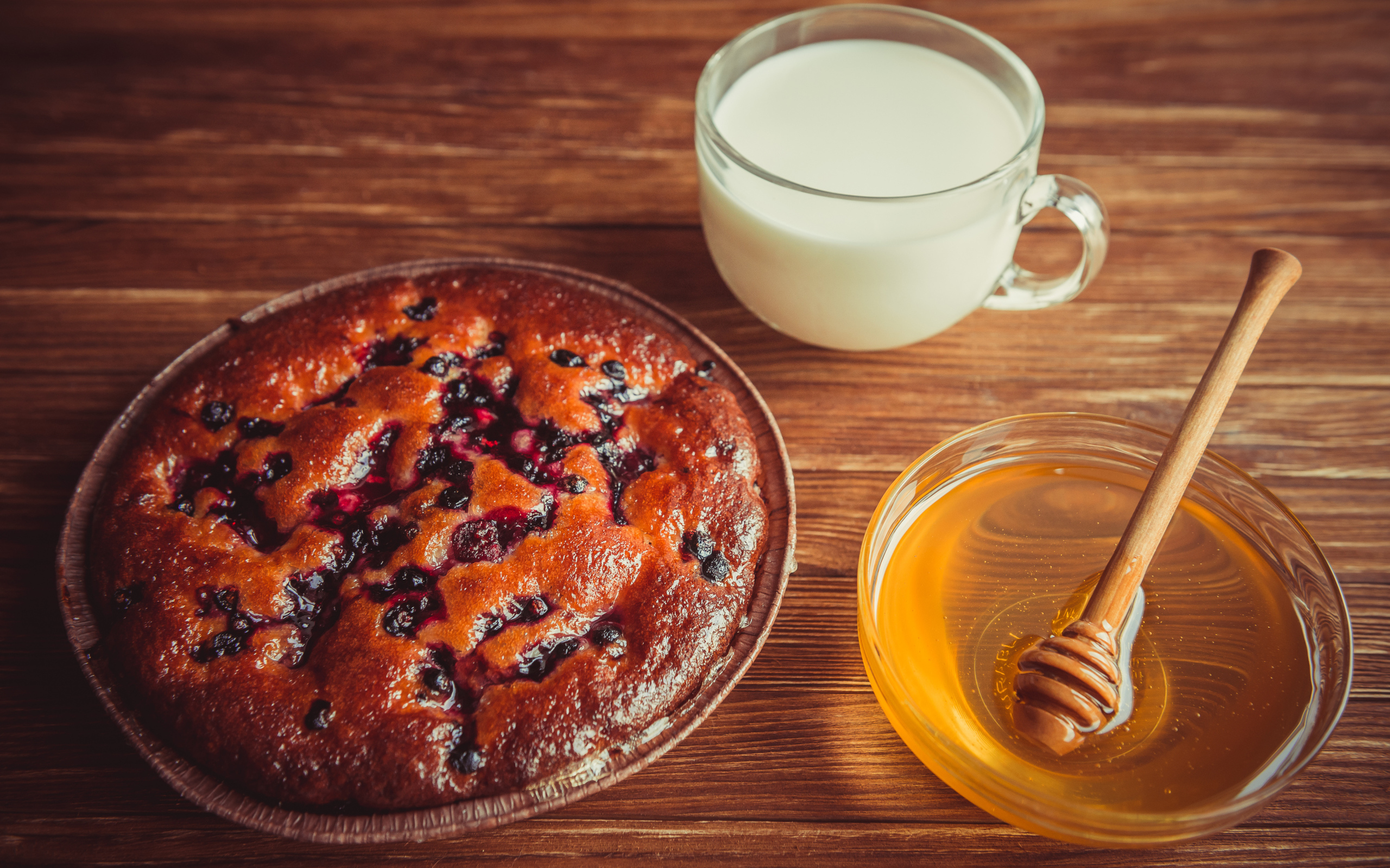 Пирог с ягодами, медом и молоком на столе