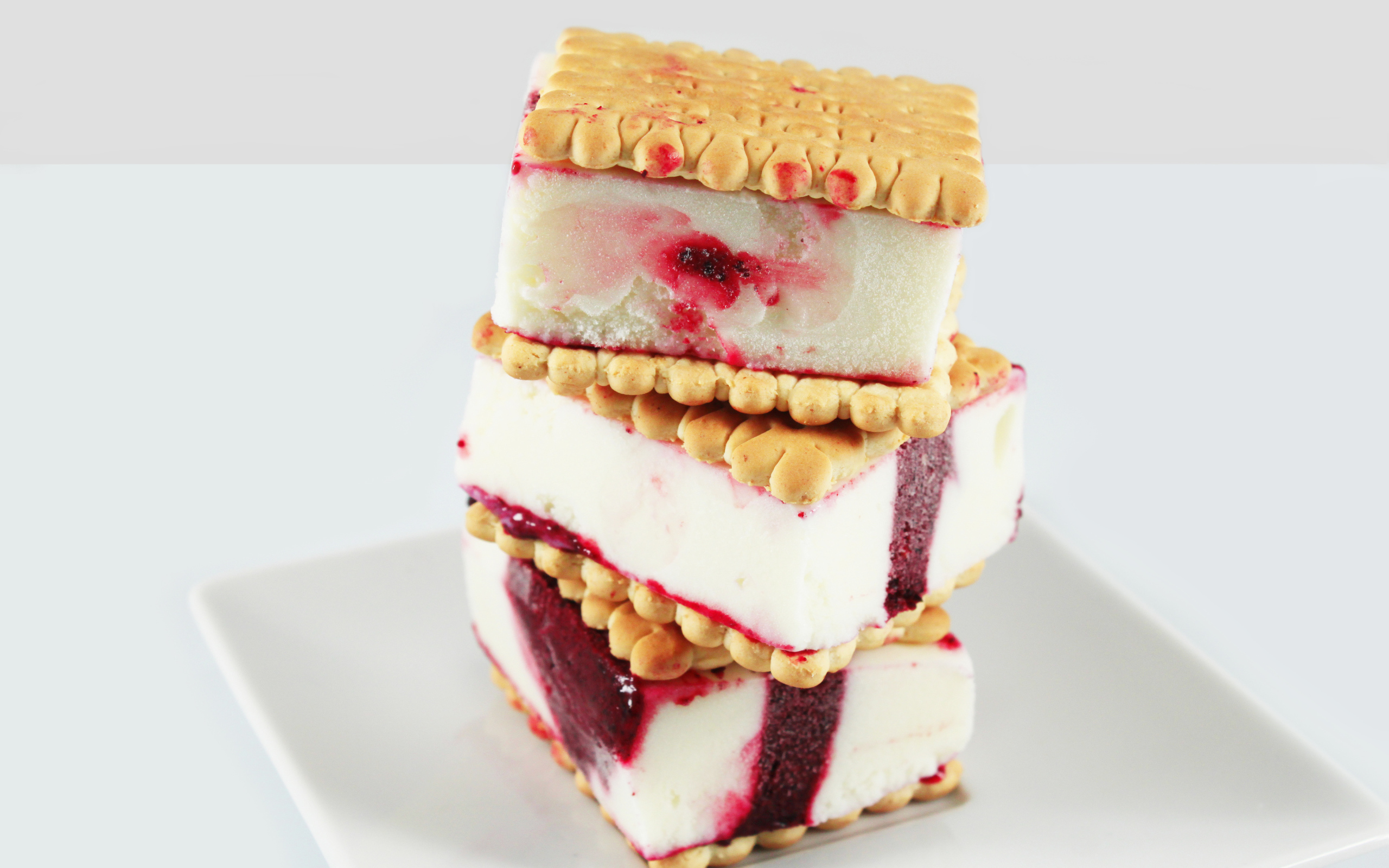 Три кусочка мороженого с печеньем на сером фоне