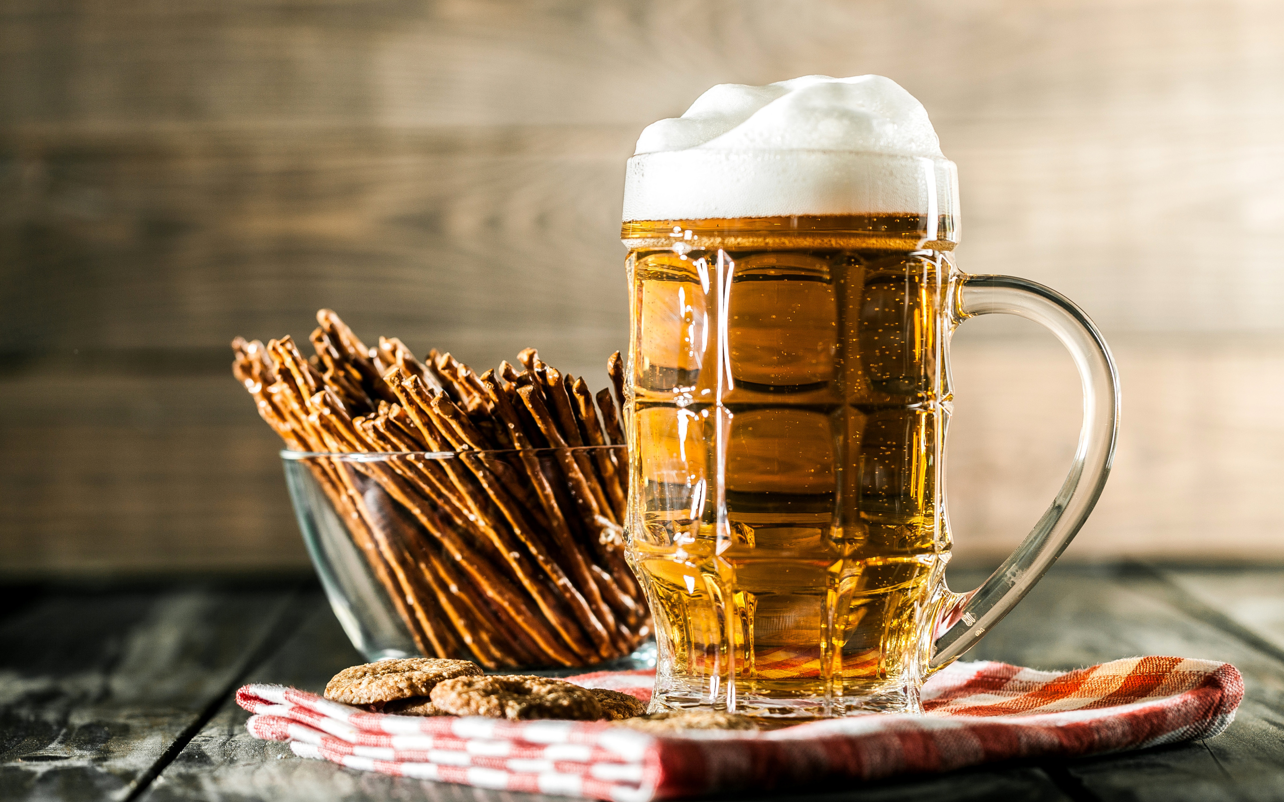 Бокал свежего пива с выпечкой на столе