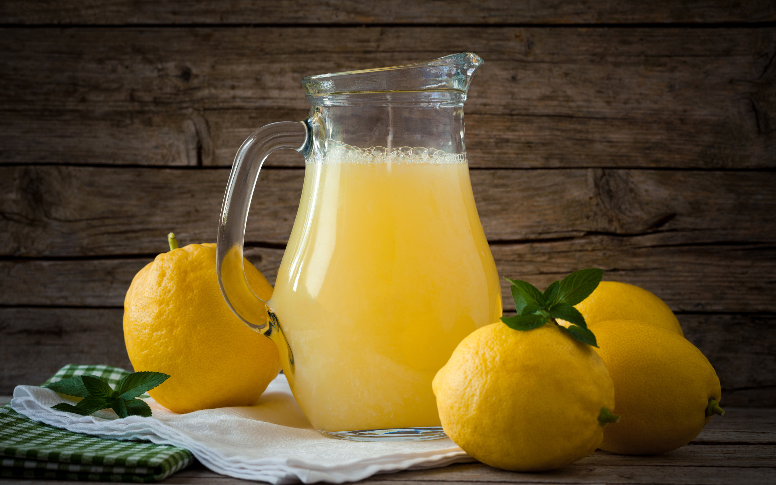 Свежевыжатый лимонад в стеклянном кувшине на столе