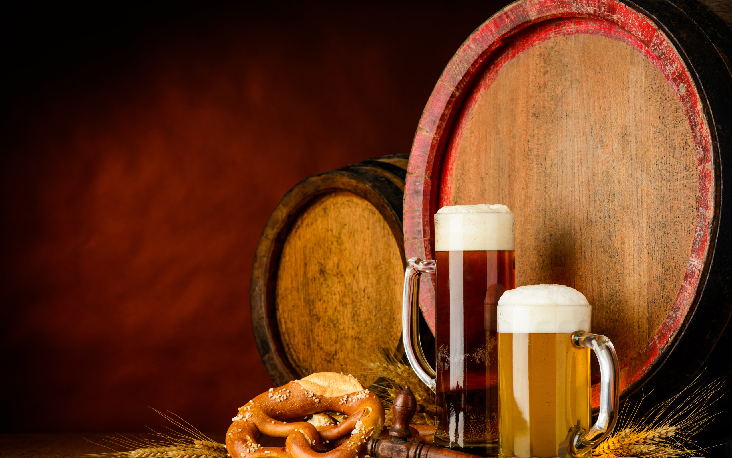 Два бокала пива и выпечка у пивных бочек