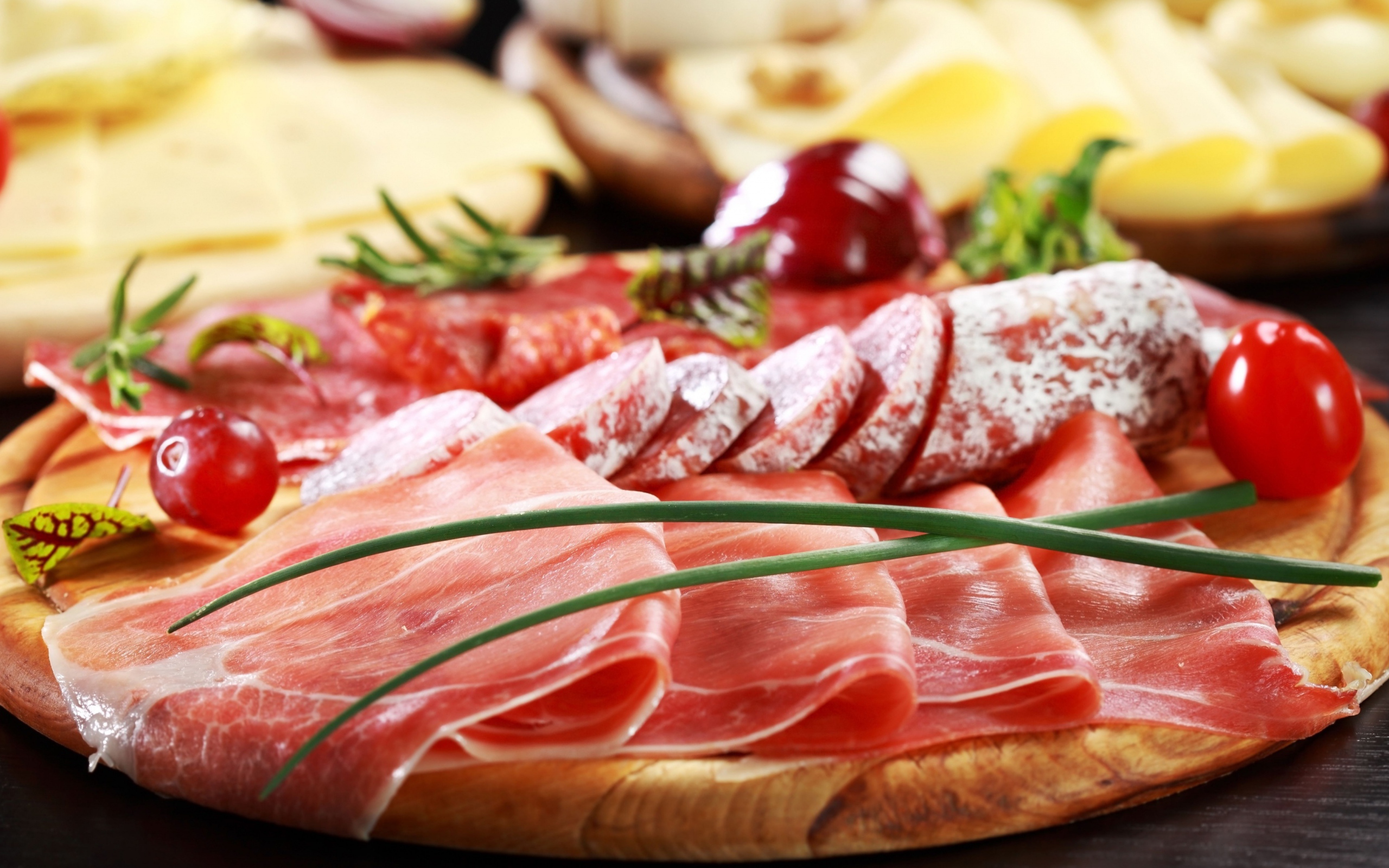 Мясная нарезка на разделочной доске с овощами